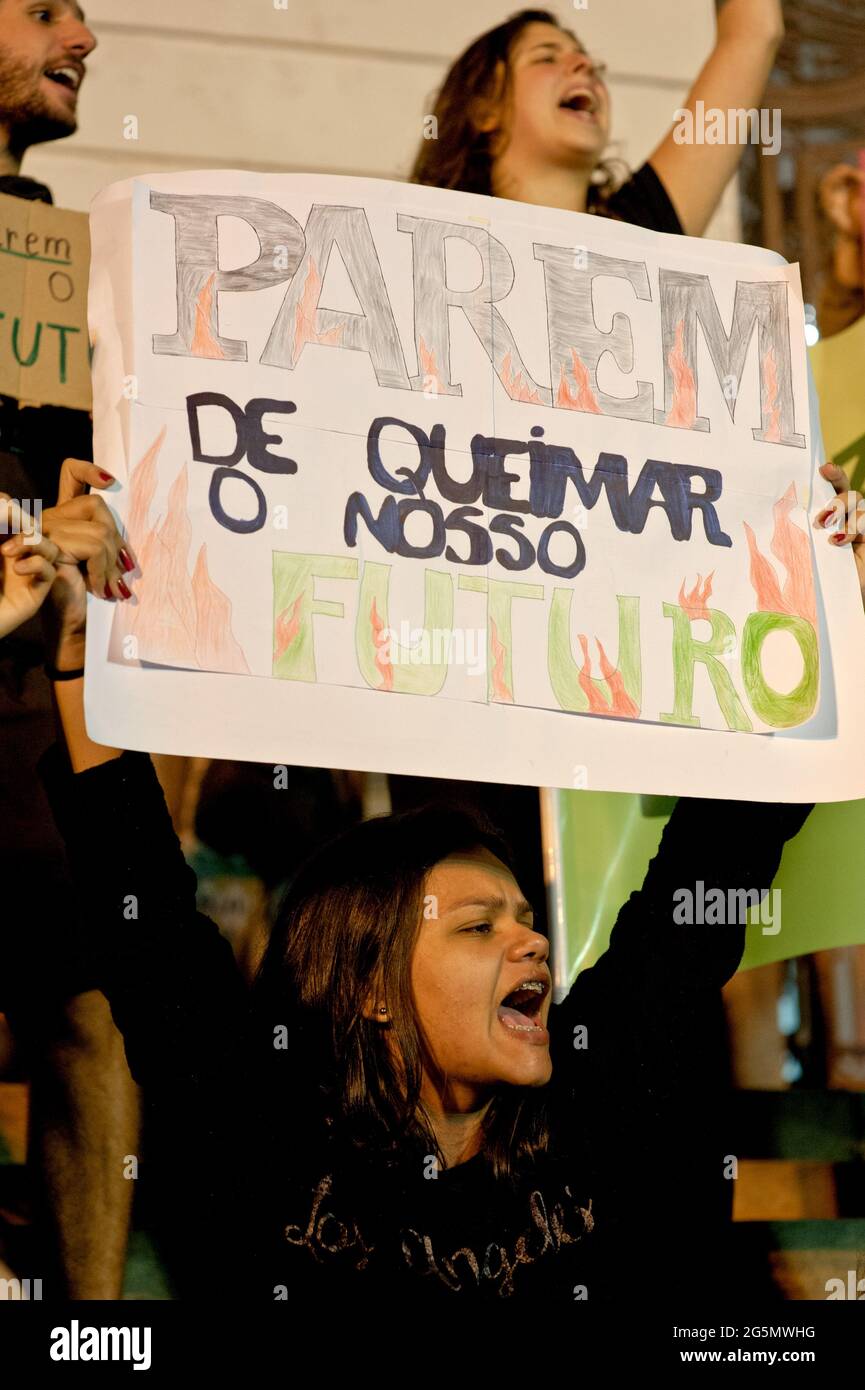 Rio de Janeiro - 23 agosto 2019: Una donna tiene un cartello che dice "Smettere di bruciare il nostro futuro" durante una protesta contro gli incendi che infuriano nell'Amazzonia. Foto Stock