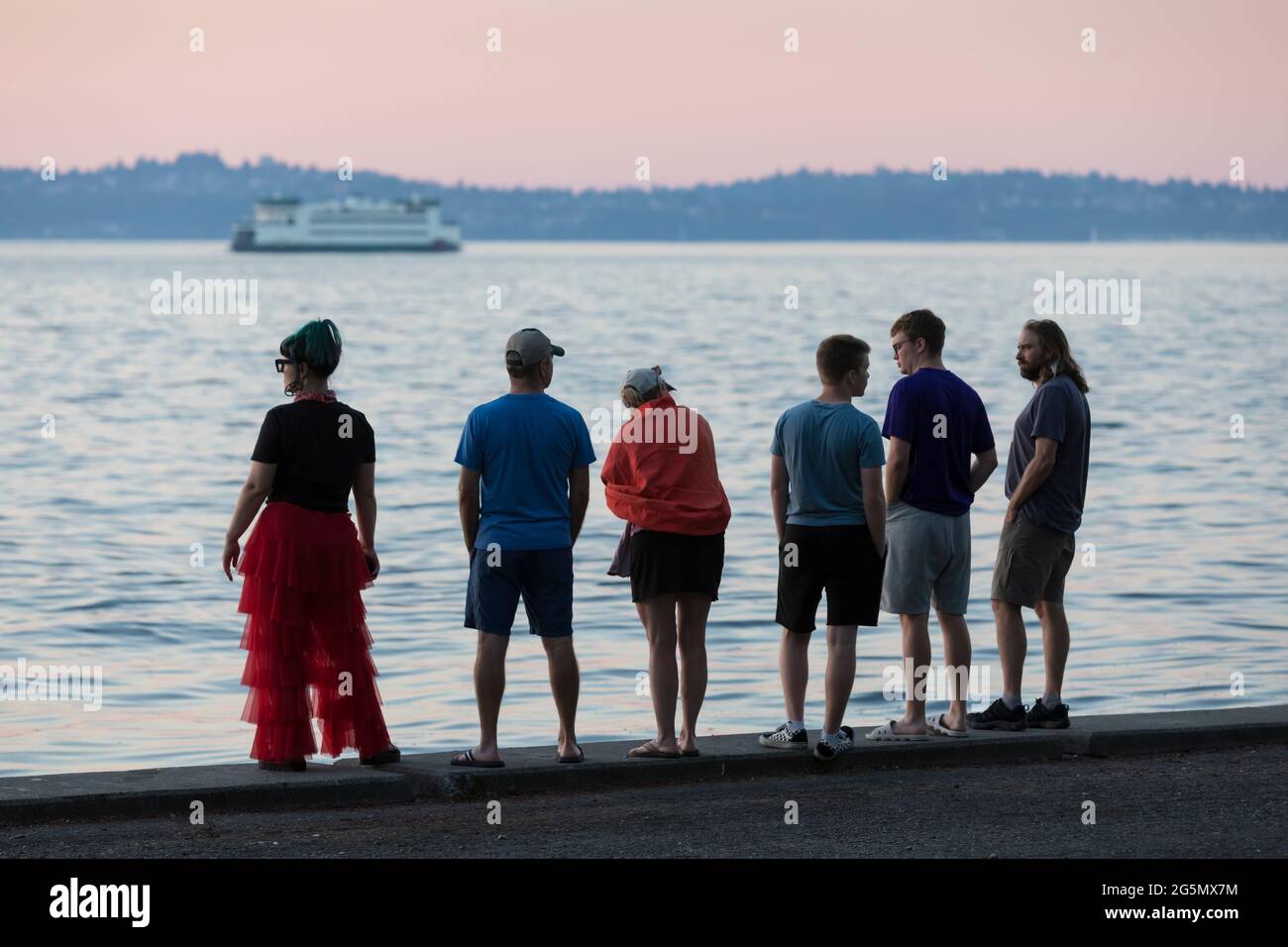 Un gruppo di visitatori può godersi il tramonto all'Alki Beach Park durante un'ondata di caldo a Seattle domenica 27 giugno 2021. Il nord-ovest del Pacifico è sweltering und Foto Stock