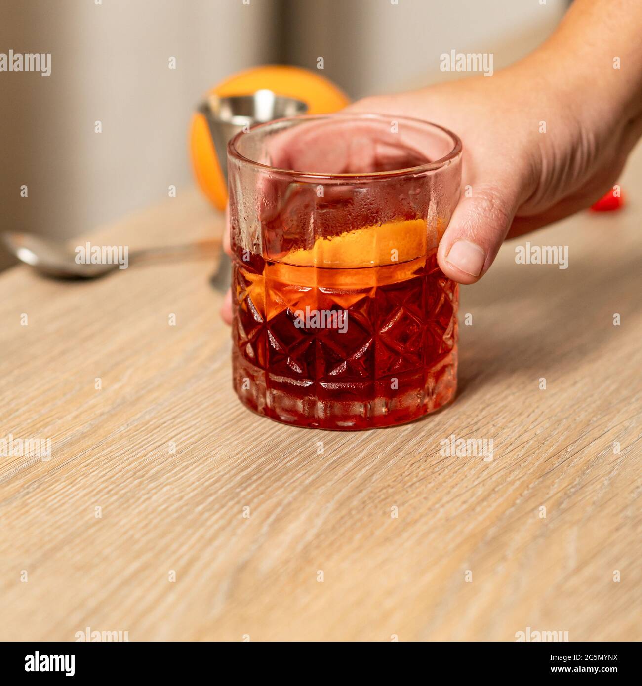 Vista panoramica del cocktail negroni sollevato con una mano Foto Stock