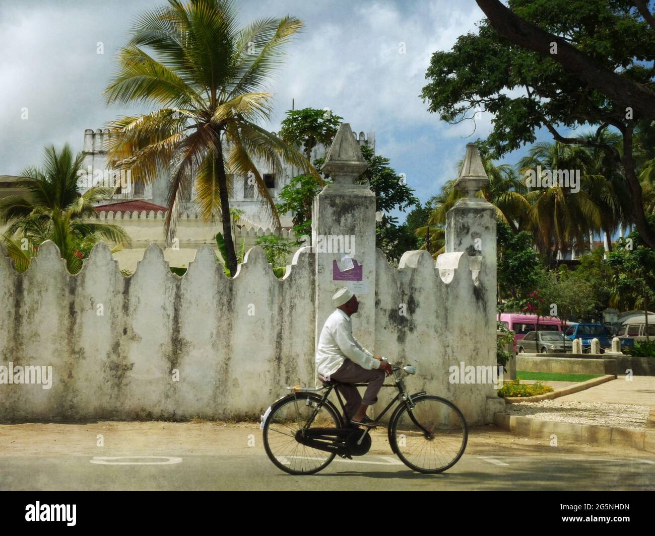 Ciclista che cavalcano il vecchio forte a Stone Town, Zanzibar Foto Stock