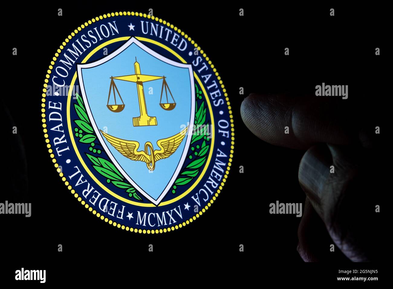 FTC Federal Trade Commission degli Stati Uniti d'America logo visto sul display in una stanza buia e dito sfocato puntando su di esso. Concetto. Foto Stock