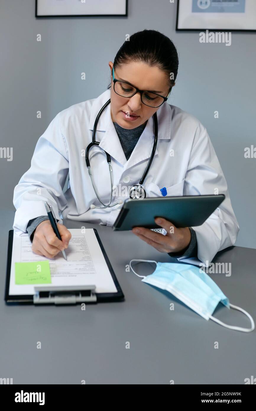 Medico femminile che fa consultazione online con la compressa Foto Stock