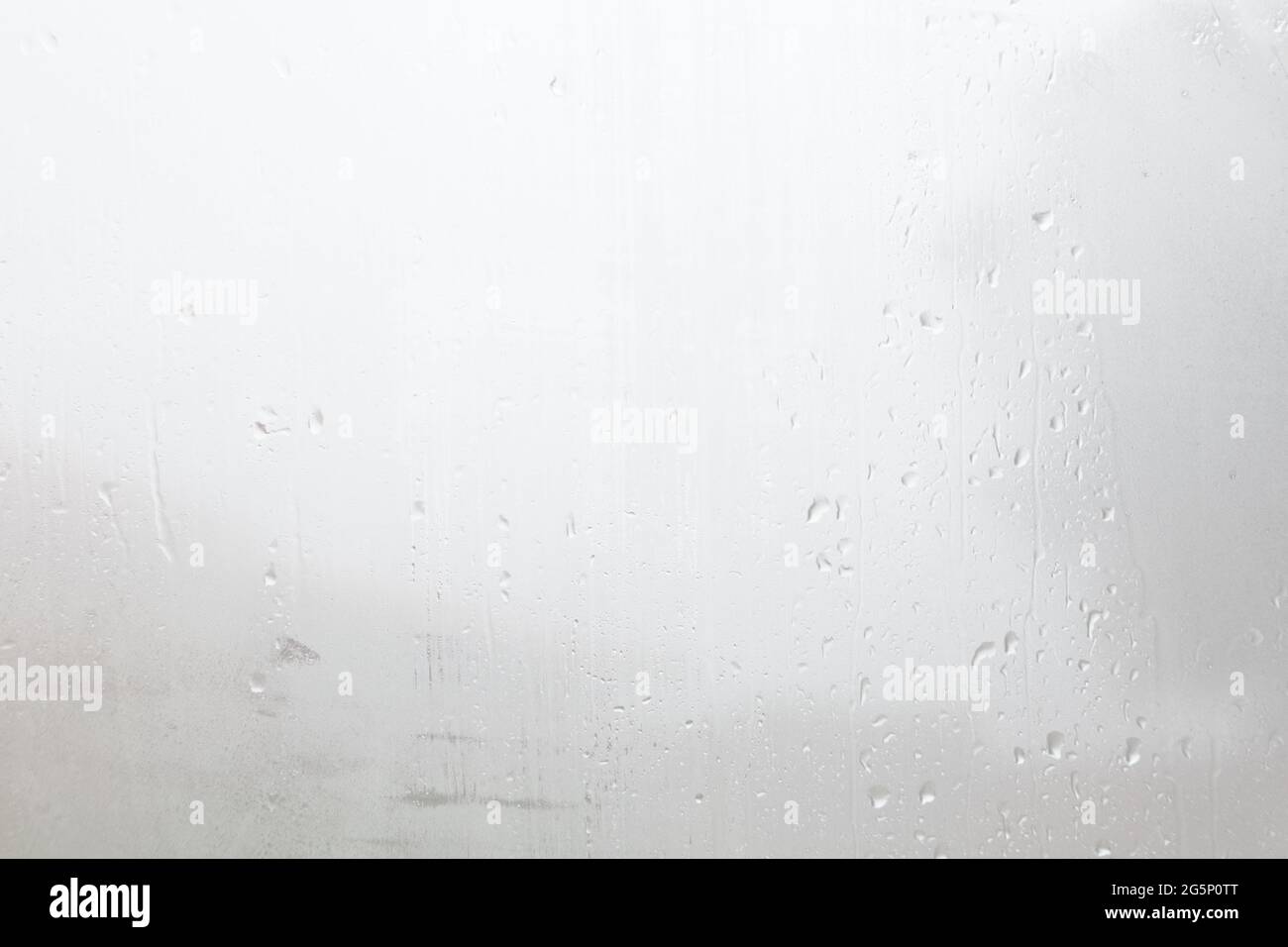 Superficie di una goccia di pioggia su un vetro bagnato sfondo trasparente. Sfondo raindrop Foto Stock