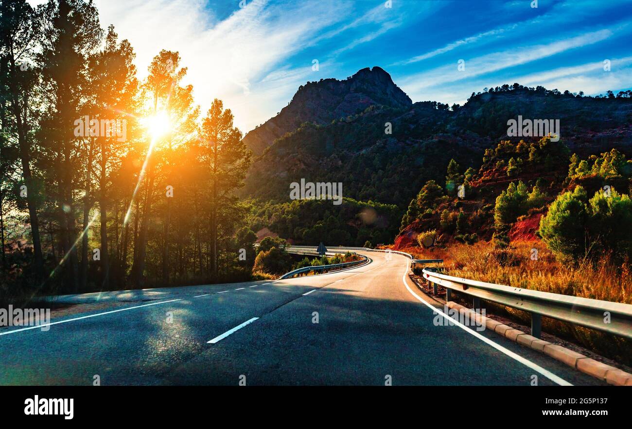 Viaggio in auto e deserto strada panoramica. Avventura e concetto di destinazione. Sfondo della strada di campagna e paesaggio colorato tramonto. Foto Stock