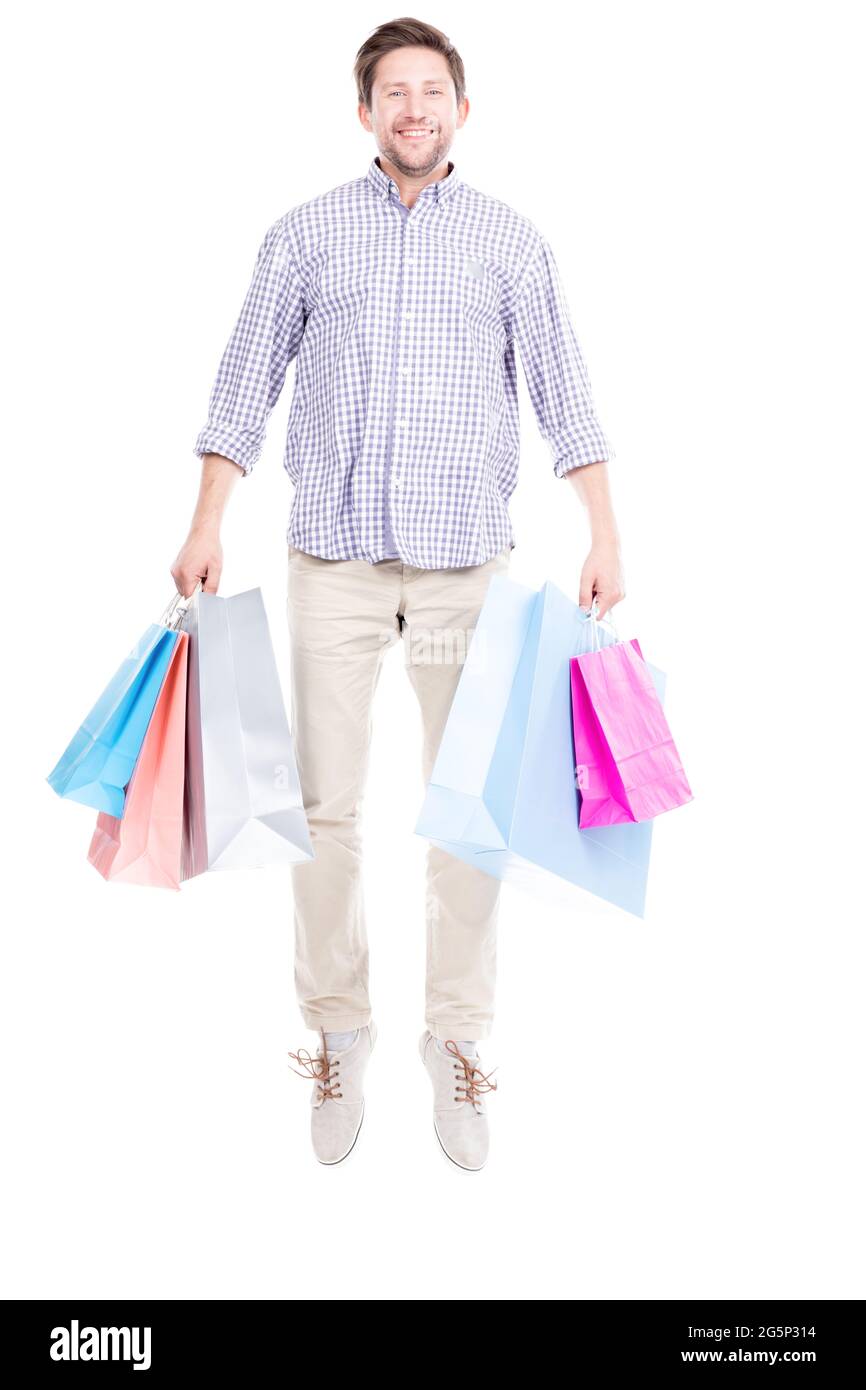 Studio ritratto scatto di giovane adulto caucasico uomo che indossa abiti casual in piedi da solo tenendo borse della spesa, sfondo bianco Foto Stock