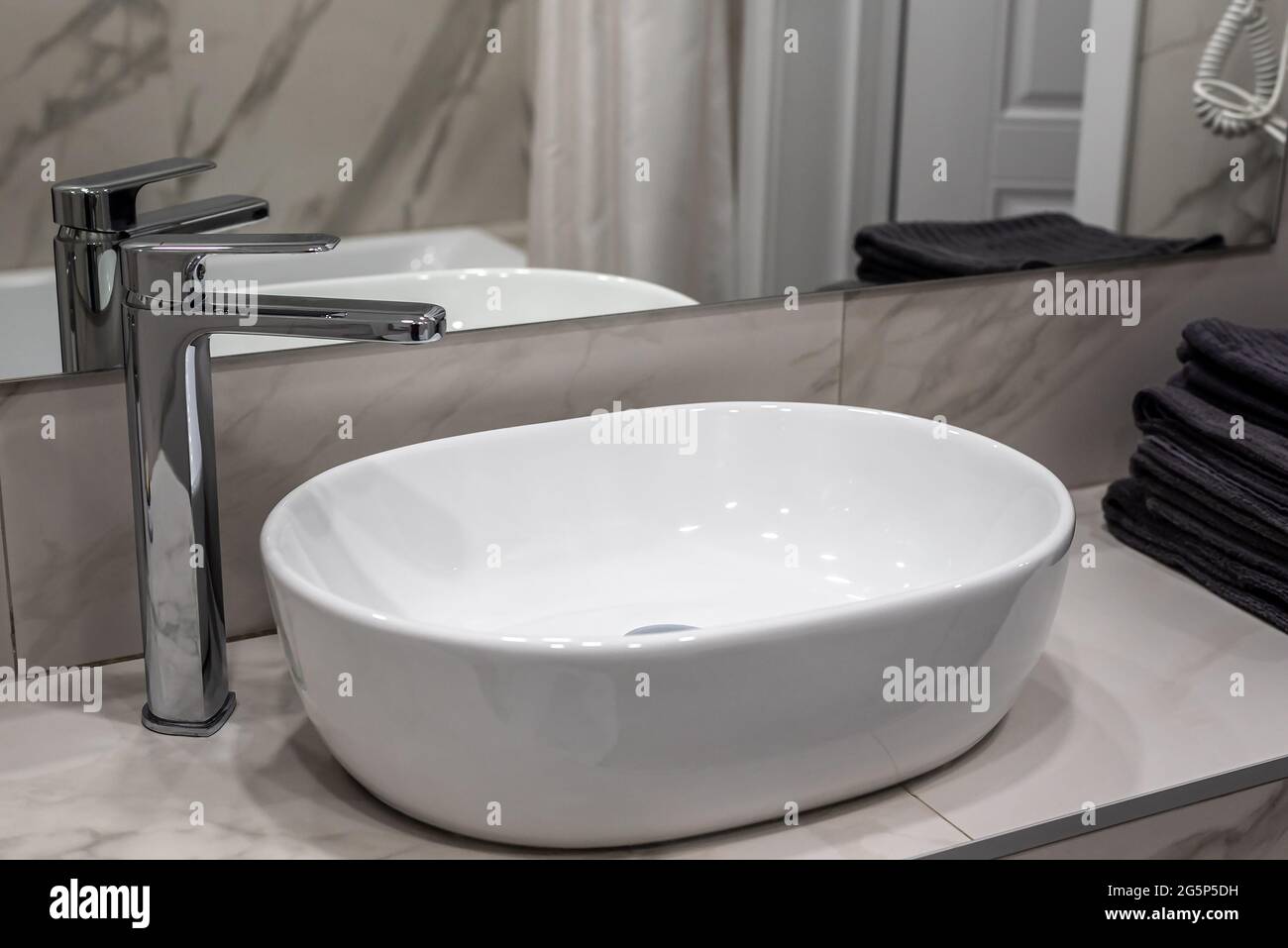 Nuovo lavello serbatoio e rubinetto lucido vicino a specchio in bagno Foto Stock