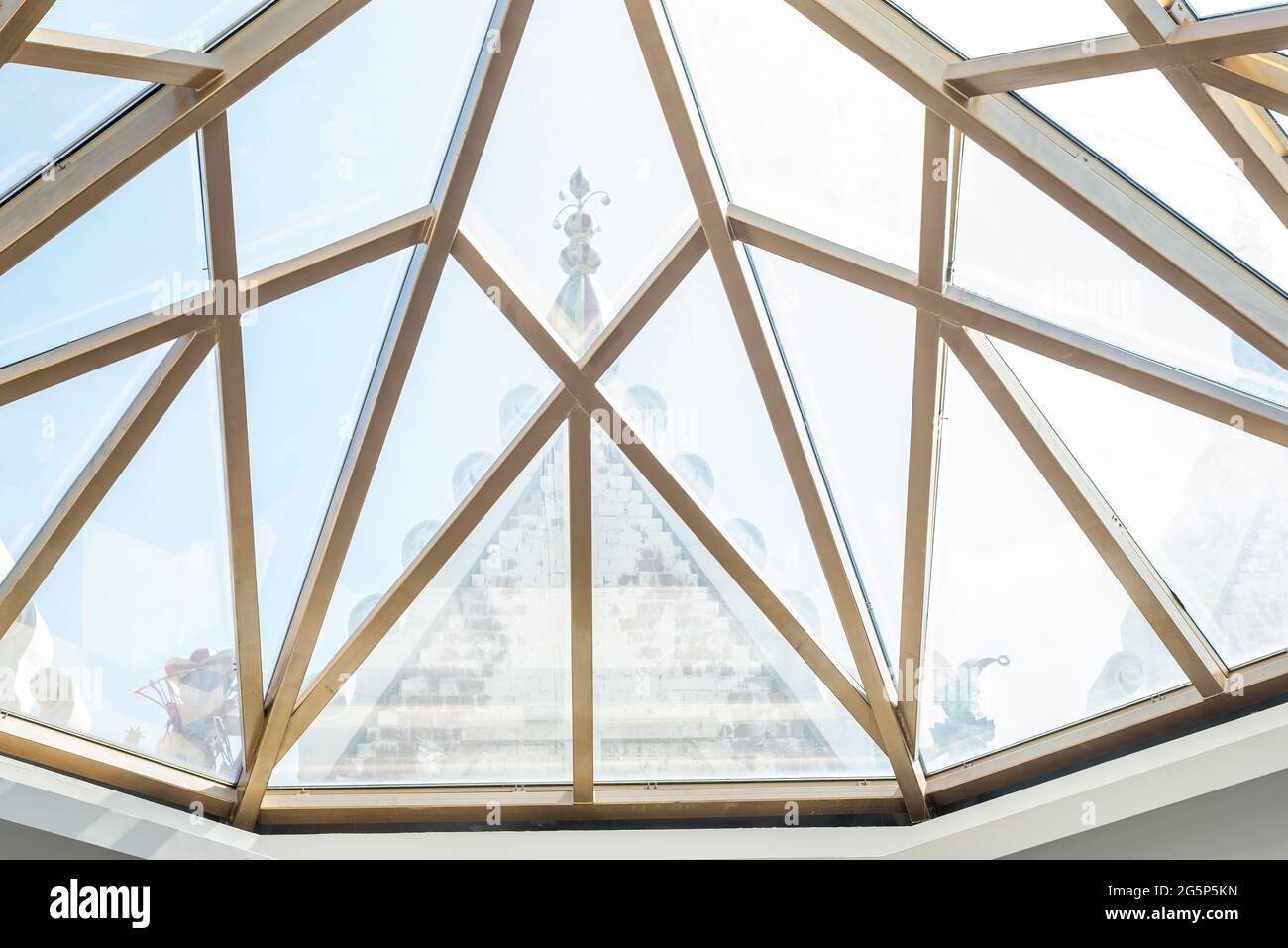 Elegante soffitto in vetro con pezzi triangolari e cornice dorata Foto Stock