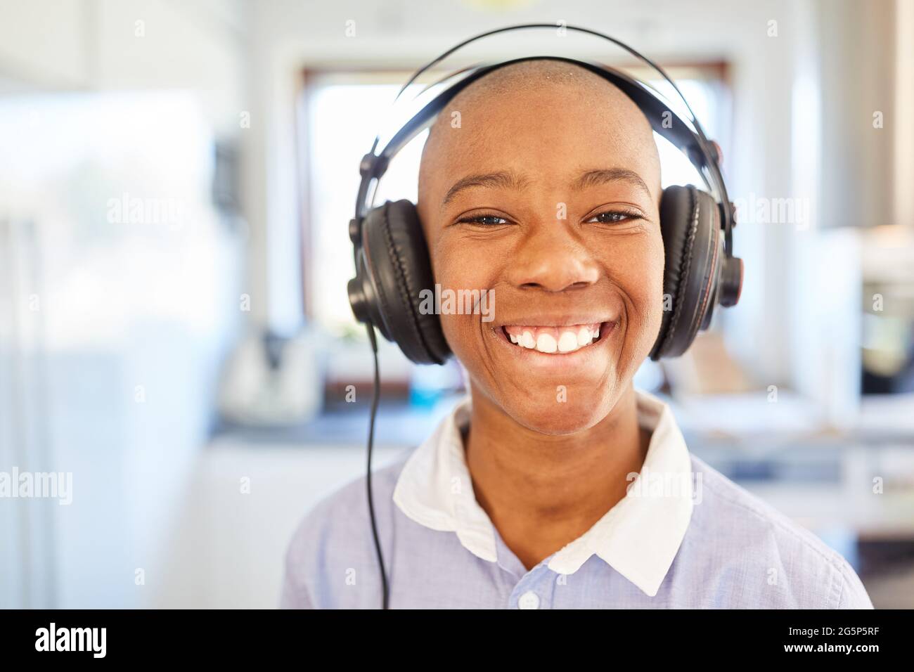 Buon bambino con le cuffie che hanno divertimento la musica in streaming in linea o l'apprendimento a distanza Foto Stock