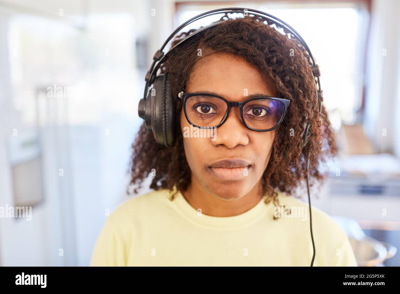 Alunno afroamericano che indossa le cuffie mentre si sta imparando a distanza e-learning a casa Foto Stock