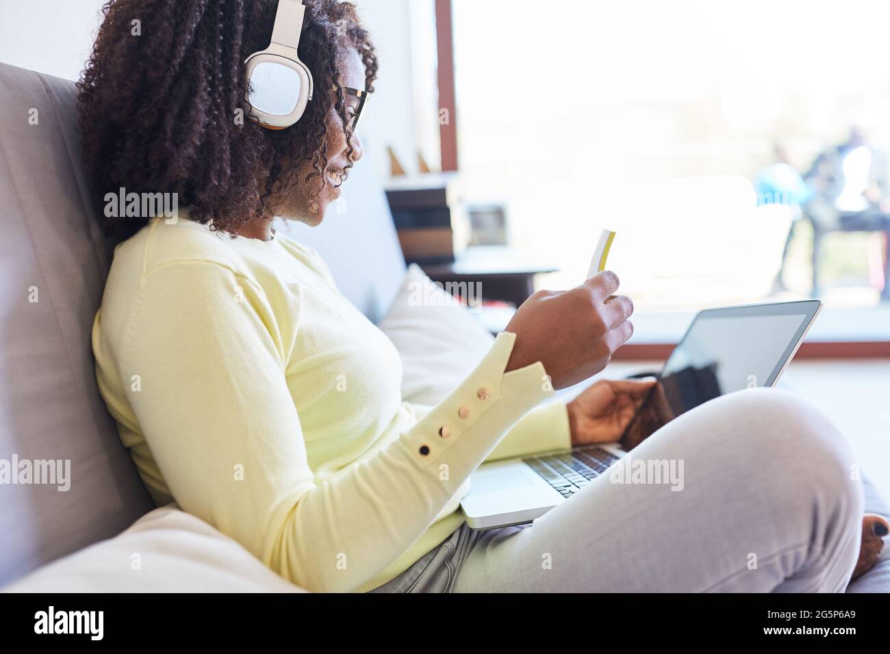 Donna afroamericana che usa il computer portatile a casa mentre dating online in un sito di incontri Foto Stock