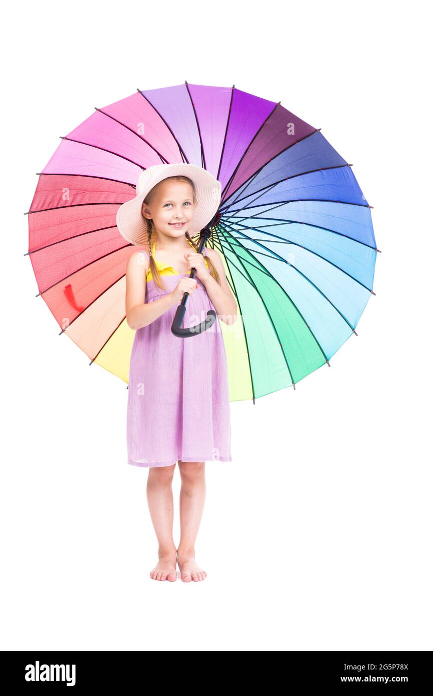 Verticale full length studio ritratto di carina ragazza caucasica che indossa abiti estivi e cappello che tiene ombrello colorato in posa sulla macchina fotografica, sfondo bianco Foto Stock
