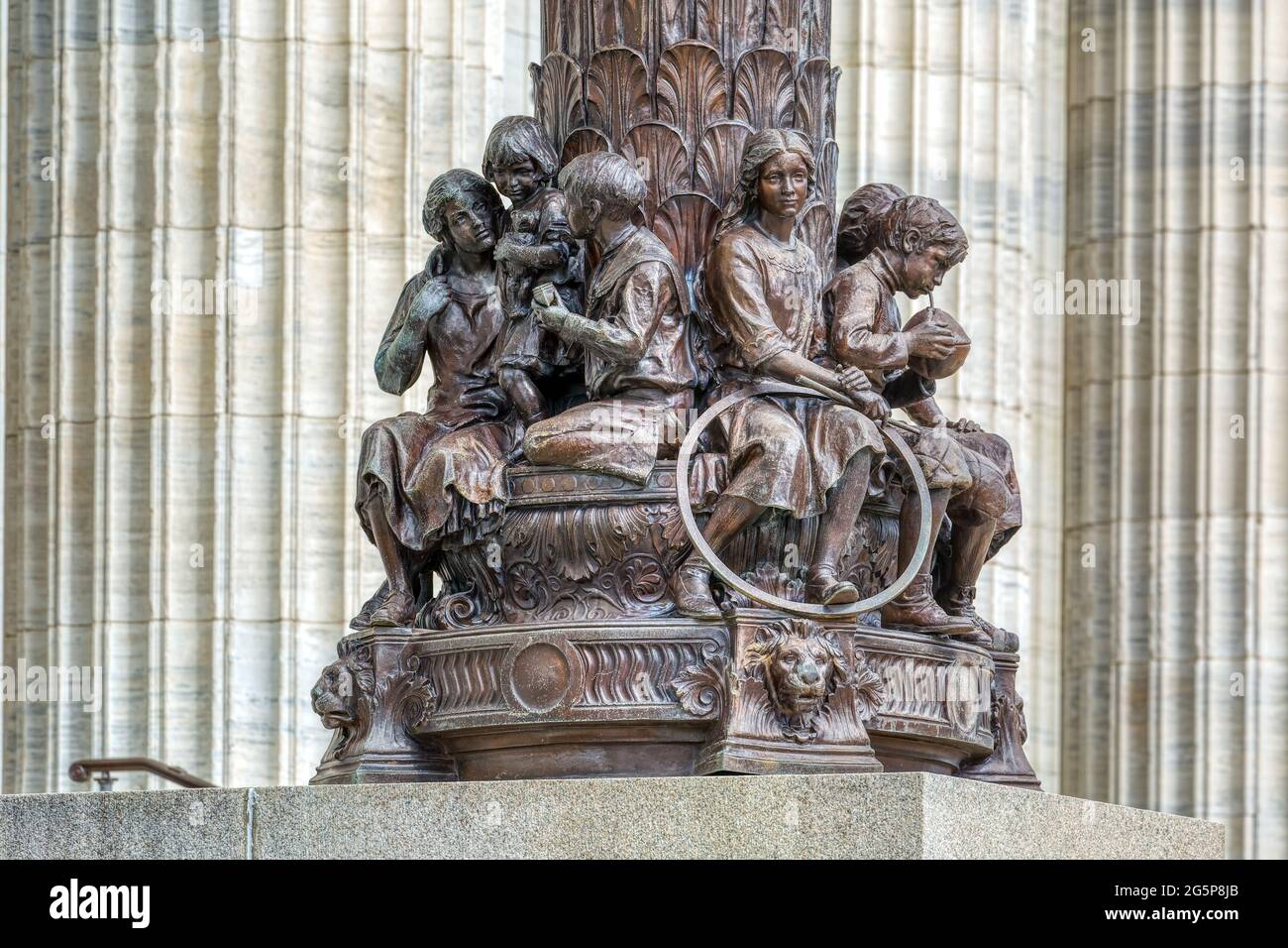 Le sculture del New York state Education Building di Charles Keck fiancheggiano i gradini di fronte al colonnato di un isolato. Foto Stock