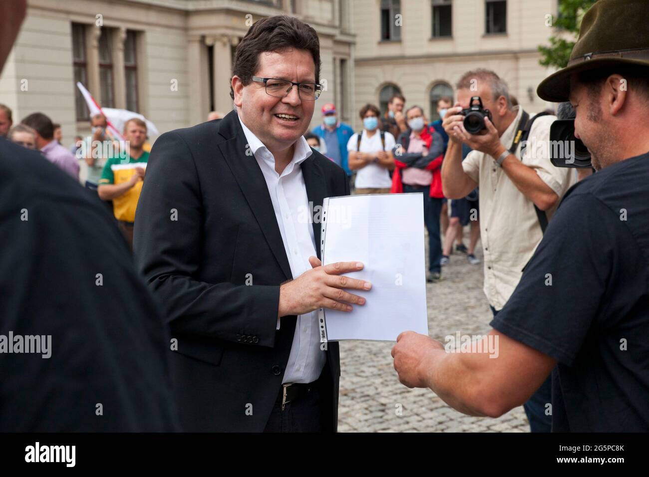 29 giugno 2021, Sassonia-Anhalt, Halle (Saale): I membri dell'IG 'Agriculture Conconnects' presentano Christian Tietje (M), Rettore dell'Università Martin Lutero, con una lettera congiunta di agricoltori della Sassonia-Anhalt e studenti dell'Università Martin Luther (MLU). Gli agricoltori della Sassonia-Anhalt e gli studenti dell'università (MLU) manifestano insieme contro i piani di riduzione dell'università, che interesserebbero anche il dipartimento di scienza agricola. Foto: Johannes Stein/dpa-Zentralbild/dpa Foto Stock