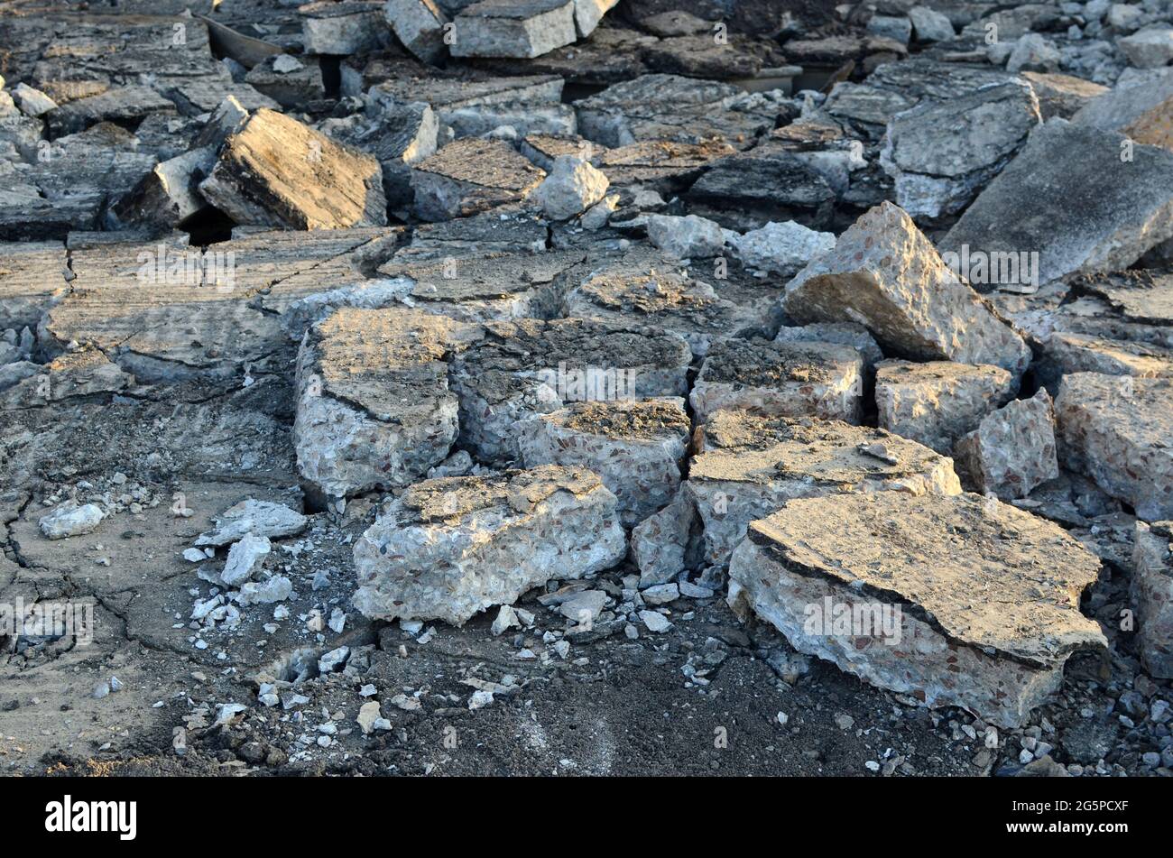 Pezzi rotti di asfalto ad un luogo di costruzione. Riciclaggio e riutilizzo di macerie di calcestruzzo frantumato, asfalto, materiale da costruzione, blocchi. Frantumato сoncrete Bac Foto Stock