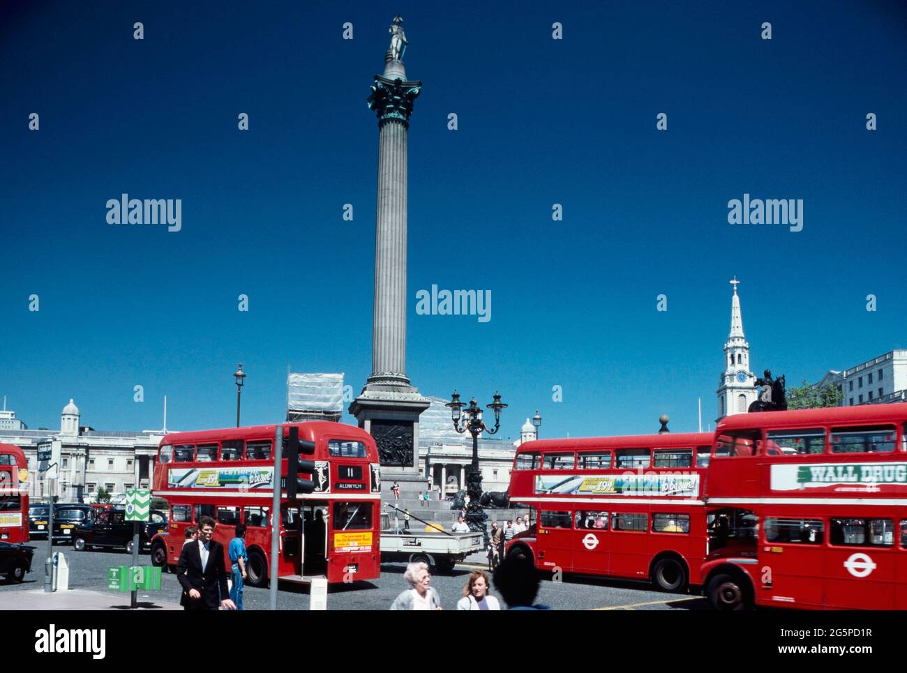 Autobus a due piani rossi lungo Trafalgar Square e la colonna di Nelson, Londra, Inghilterra, Regno Unito. Circa1980 Foto Stock