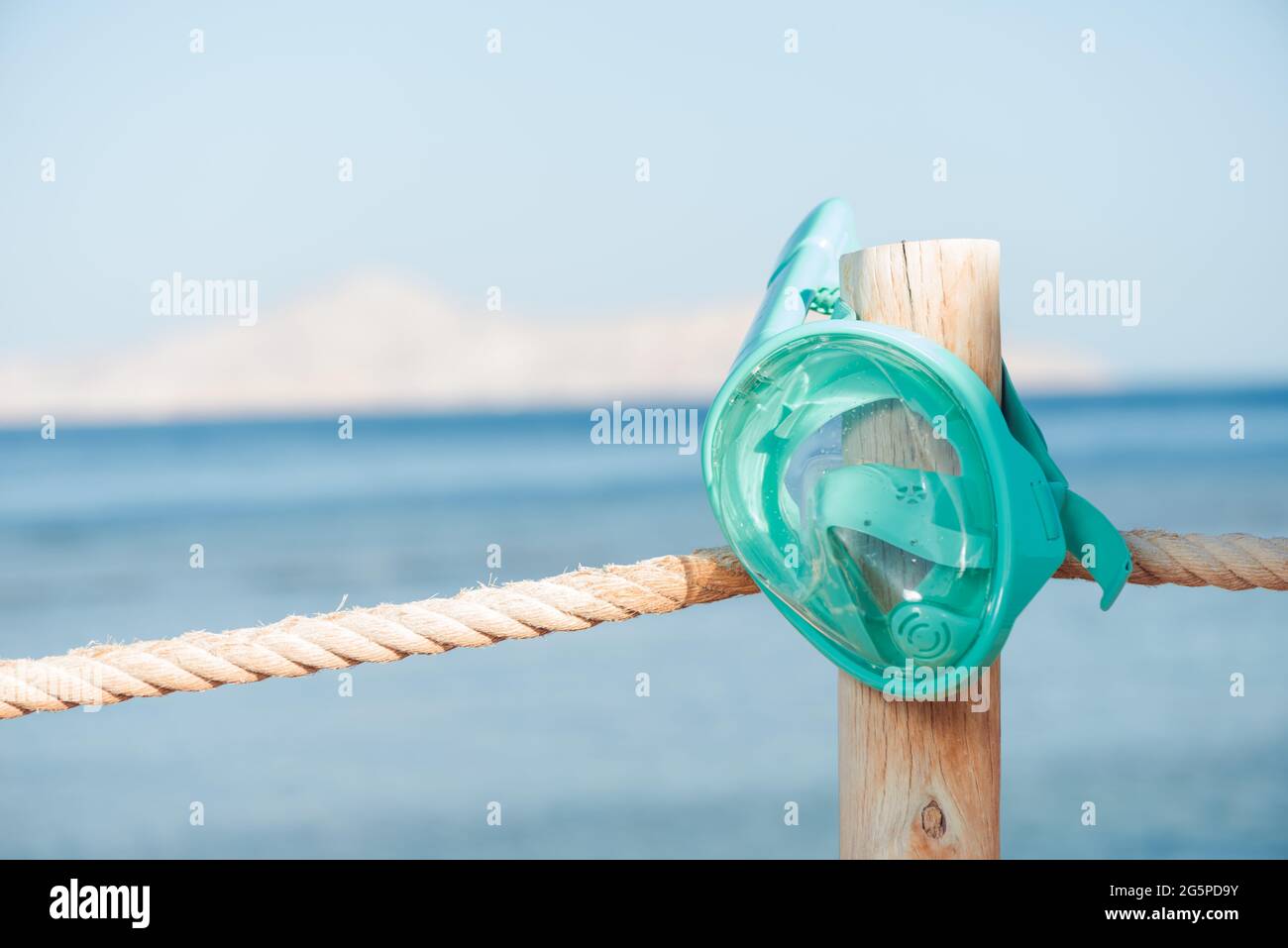 maschera subacquea su recinzione in legno sullo sfondo della spiaggia di sabbia Foto Stock