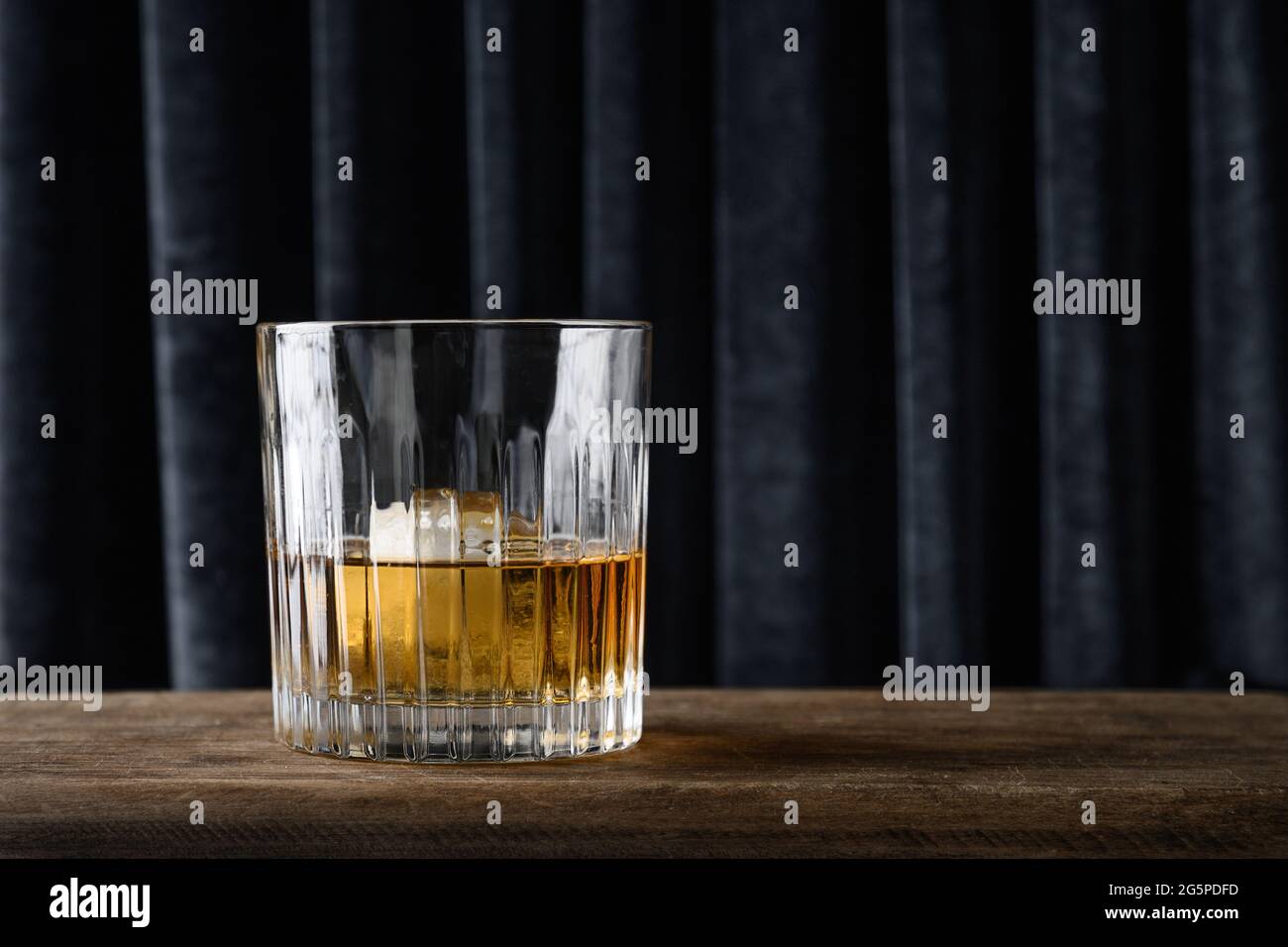 Whisky freddo in rocce su una tenda blu scuro sfondo trendy. Spazio per il testo. Foto Stock