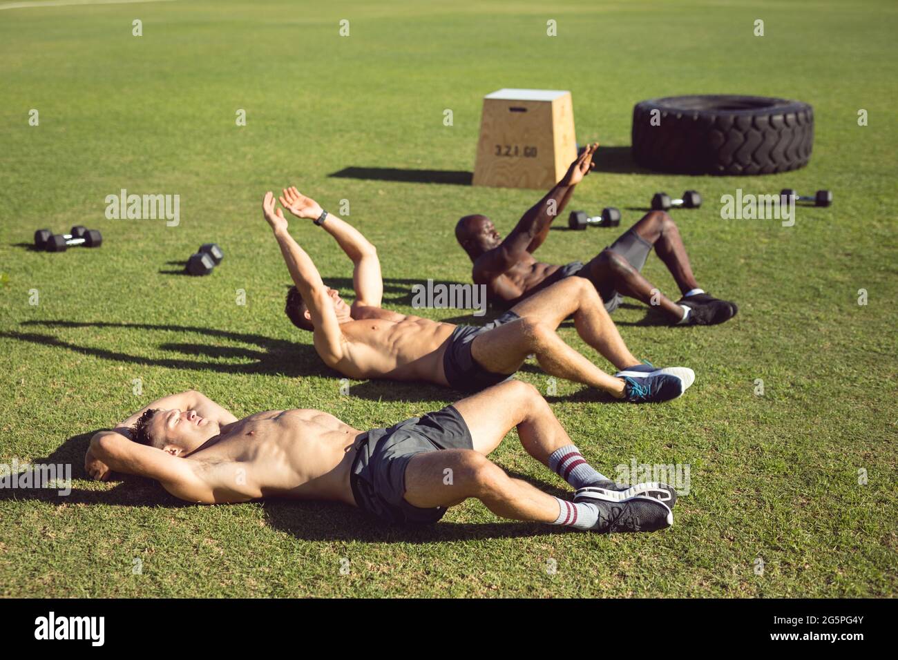 Gruppo vario di uomini muscolari che si esercitano all'aperto Foto Stock