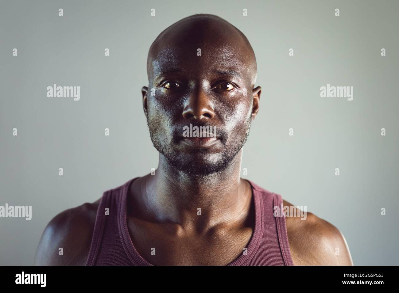 Ritratto di uomo afroamericano in forma che si esercita in palestra, guardando direttamente alla macchina fotografica Foto Stock