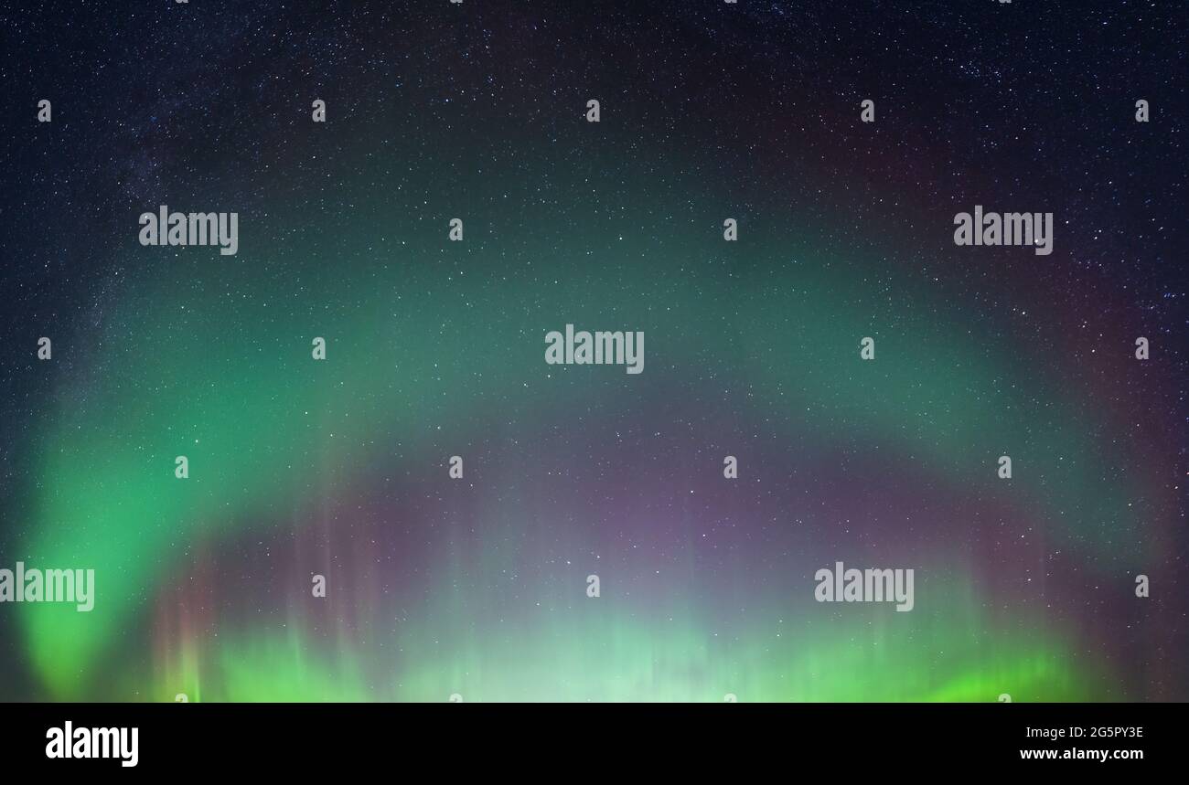 Foto reale di bella aurora boreale morbida - luci curve verdi luminose su chiaro senza nuvole cielo stellato notte nero. Un sacco di stelle reali visto in Foto Stock