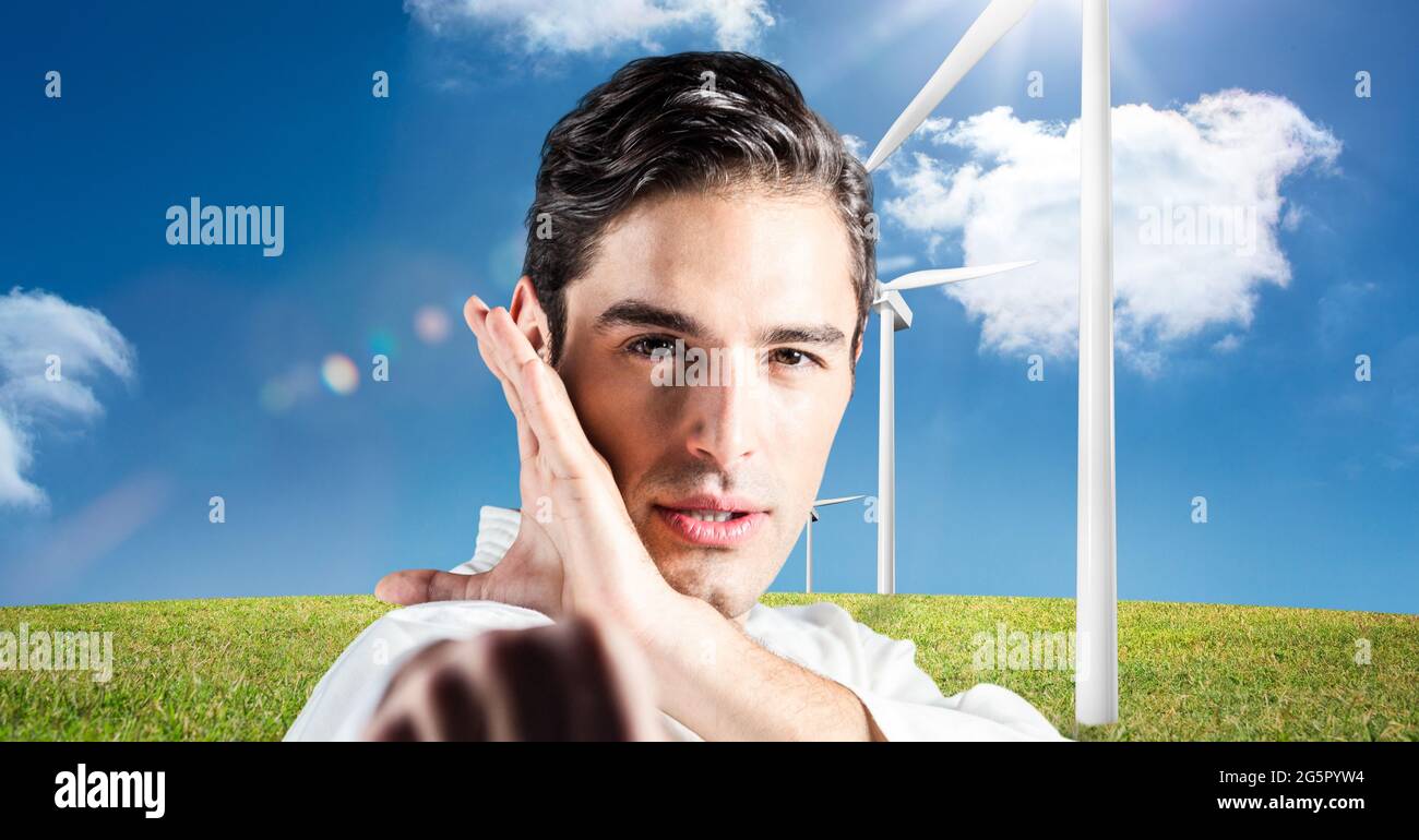Immagine digitale composita di ritratto di artista coniugale maschile caucasico contro mulini a vento Foto Stock