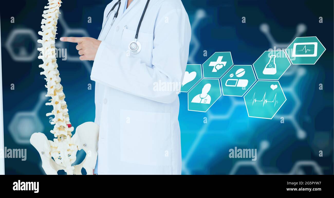 Sezione centrale del medico che tiene il modello umano della colonna vertebrale contro le icone mediche su sfondo blu Foto Stock