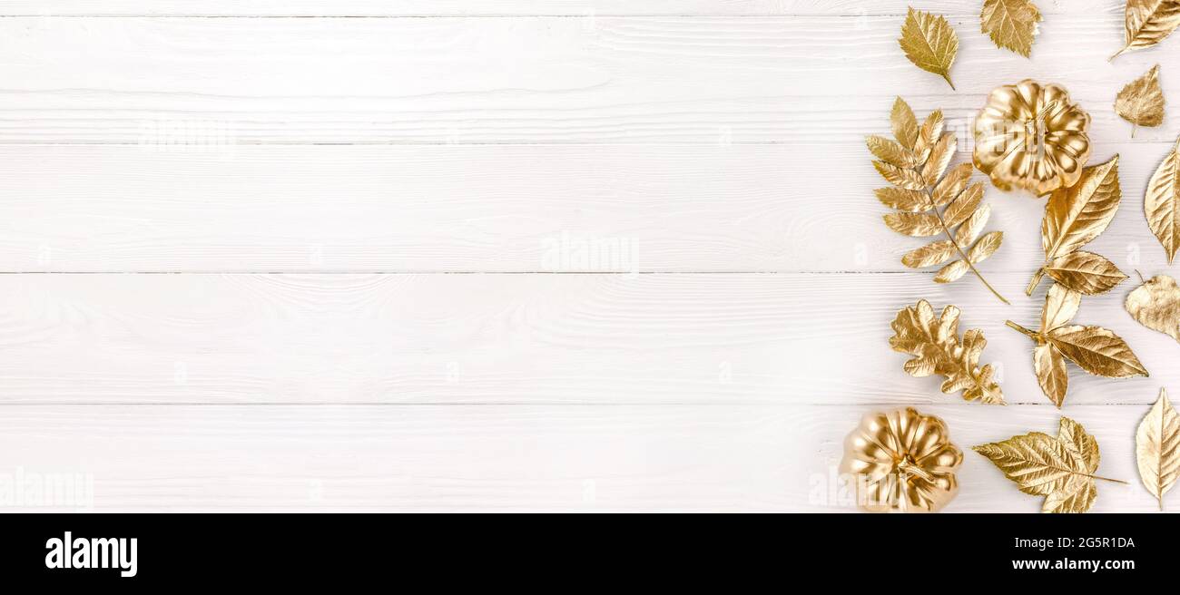 Foglie d'oro d'autunno su sfondo bianco di legno. Concetto autunnale. Vista dall'alto delle foglie autunnali in oro dipingono su bianco con spazio per la copia del testo Foto Stock
