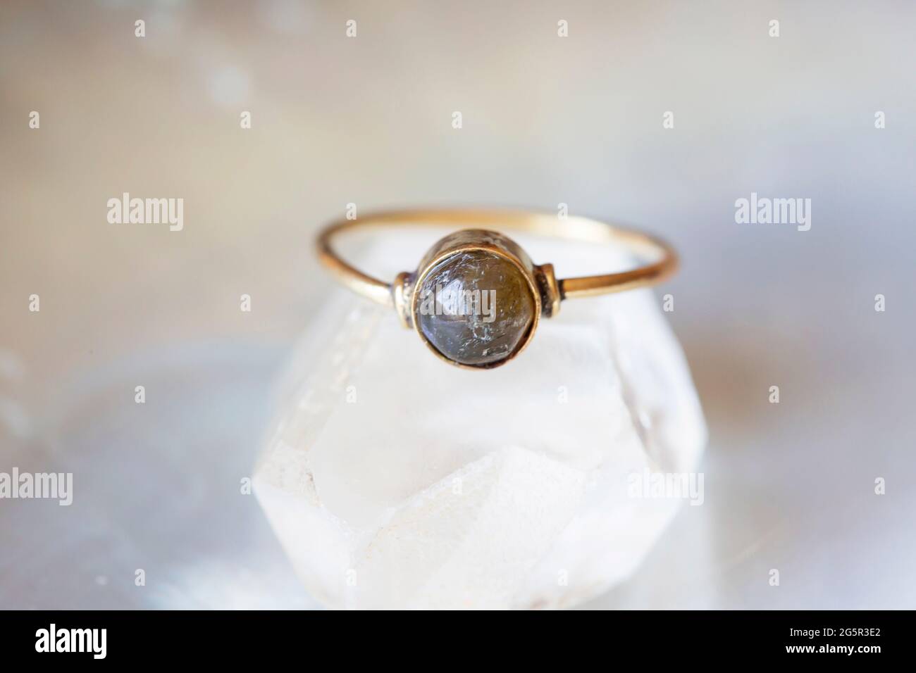 anello in ottone con pietra minerale su sfondo naturale Foto Stock