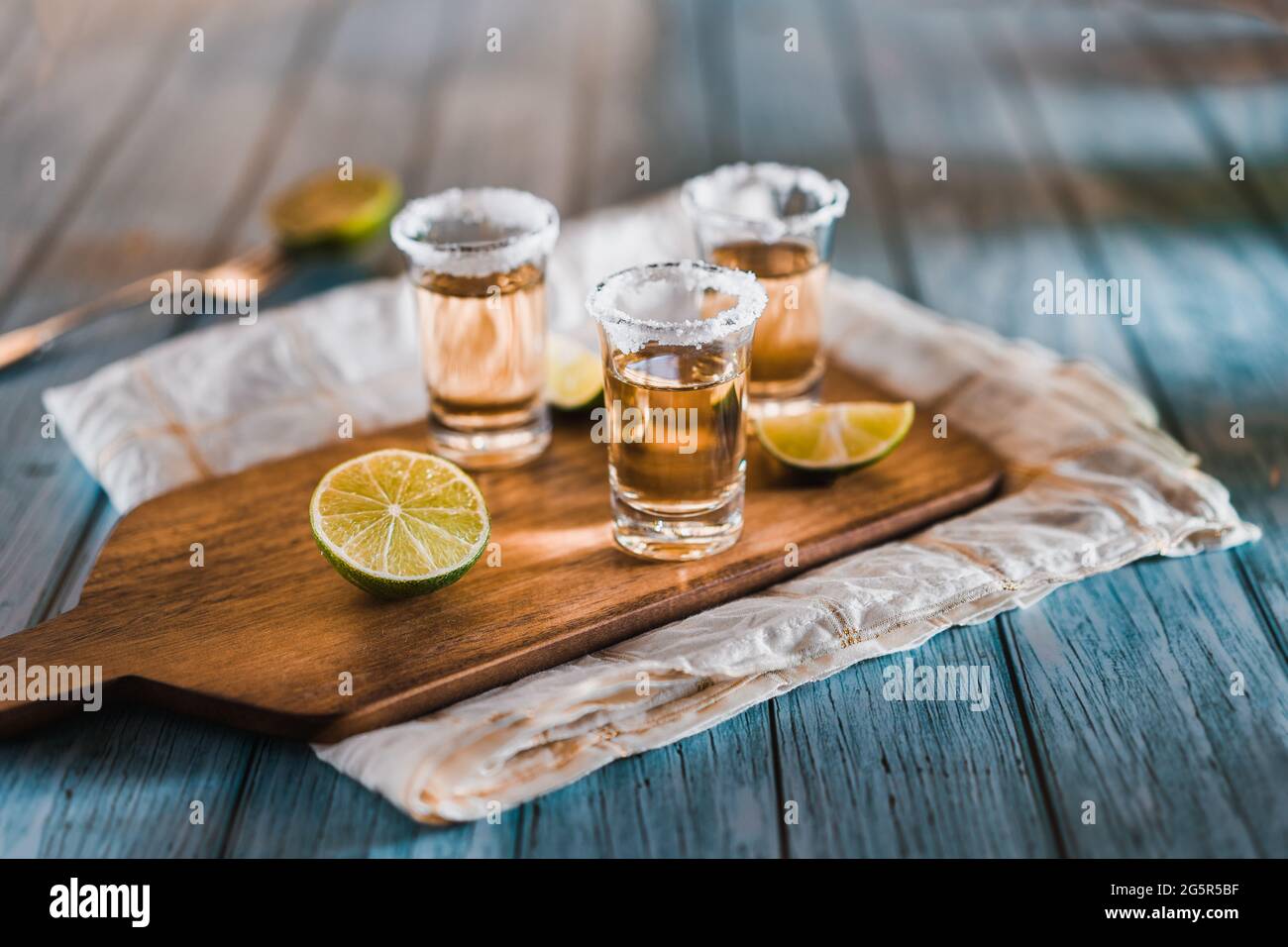Fotografia scura di colpi di tequila con le fette del sale e del limone su una tavola di legno con copyspace. Foto Stock