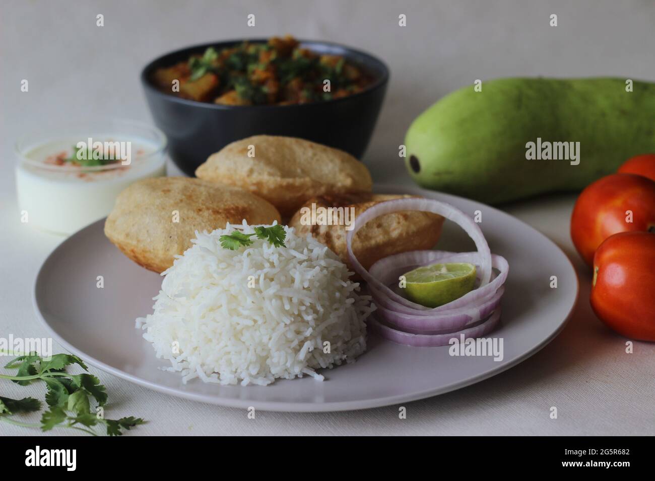 Piatti vegetariani dell'India del Nord. Una pentola per la preparazione di lenticchie e zucca servita con riso basmati al vapore e piatto indiano di grano intero fritto Foto Stock