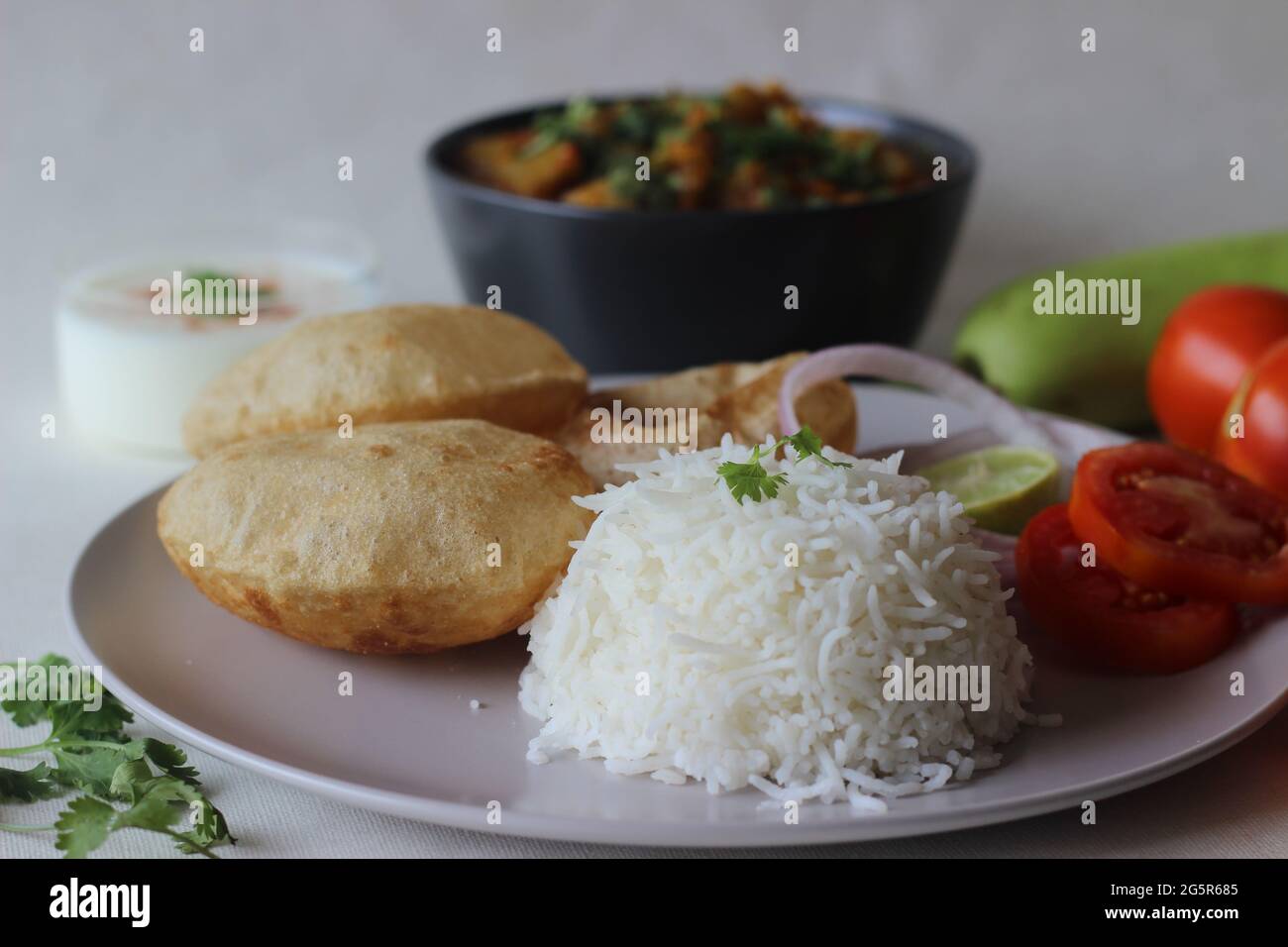 Piatti vegetariani dell'India del Nord. Una pentola per la preparazione di lenticchie e zucca servita con riso basmati al vapore e piatto indiano di grano intero fritto Foto Stock