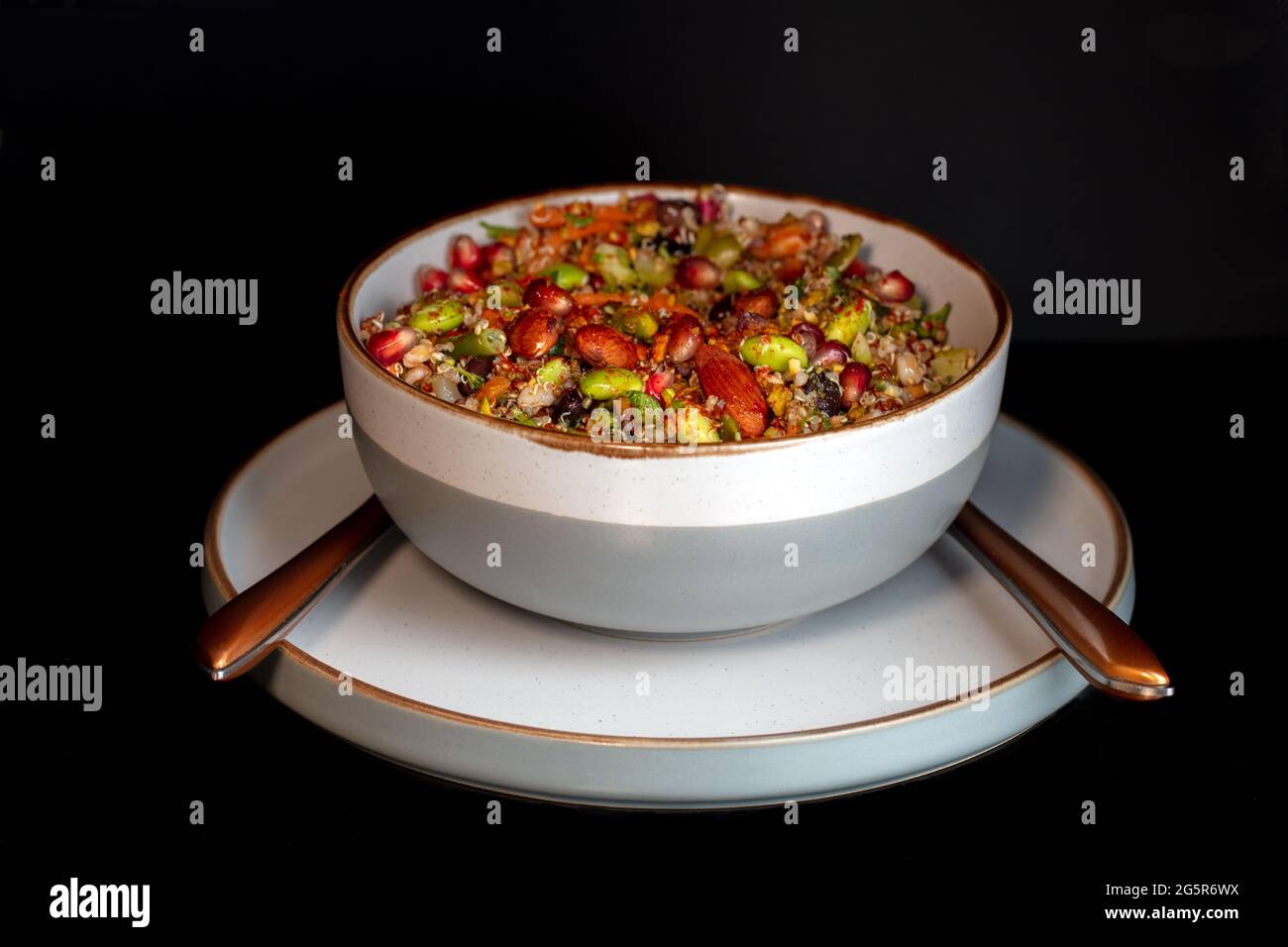 Insalata di noce di legno integrale guarnita con melograno, un gustoso pranzo vegano Foto Stock