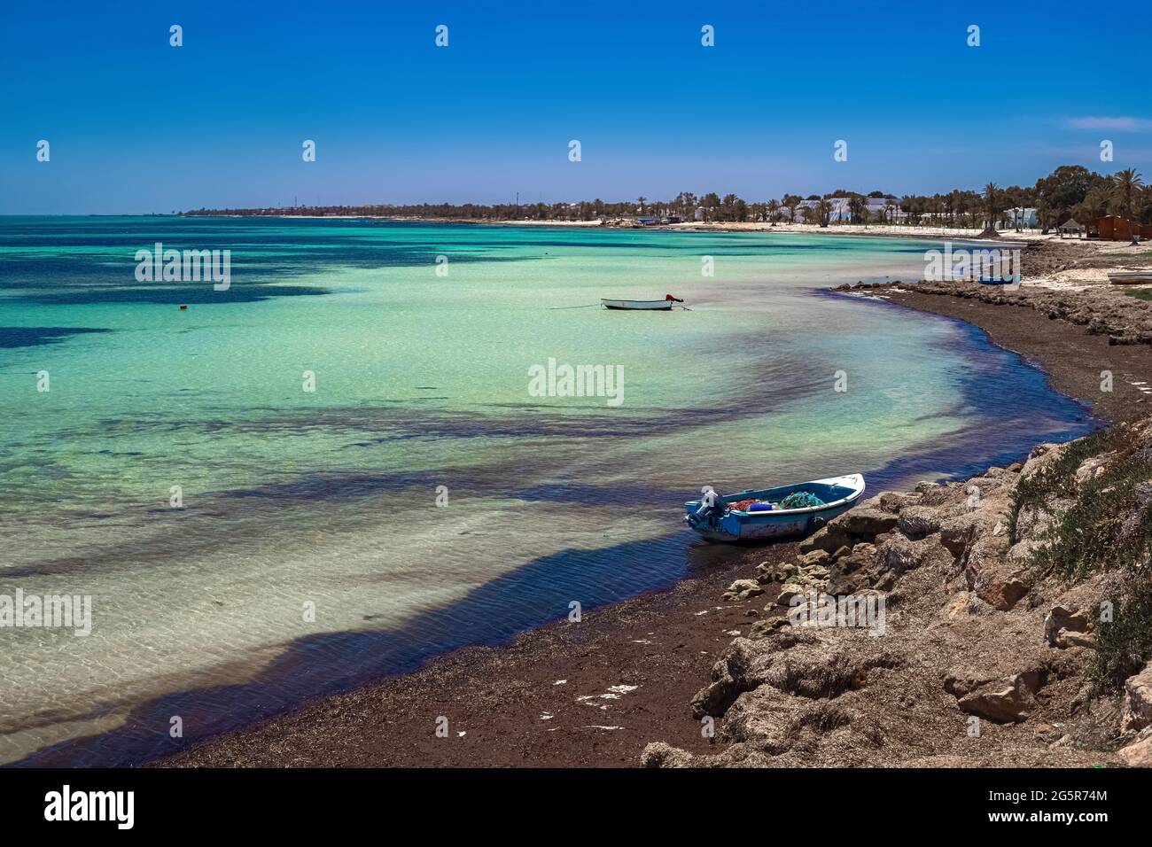 Splendida vista sulla costa mediterranea con acqua di betulla, spiaggia di sabbia bianca e barca da pesca Foto Stock