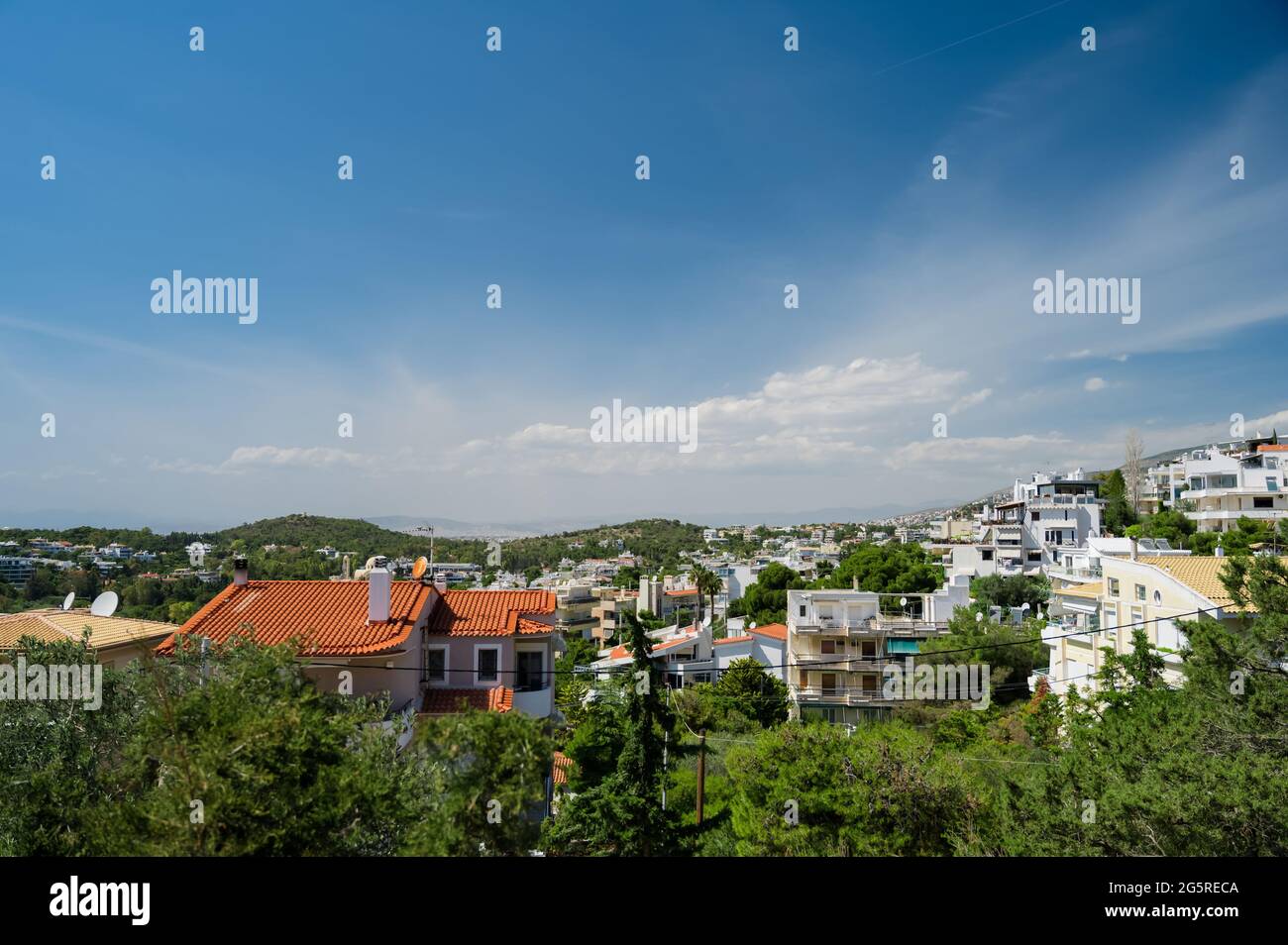 Paesaggio urbano di Atene in Grecia. Vista dall'alto. Architettura urbana e molti alberi verdi. Zona collinare. Giorno di sole. Foto Stock