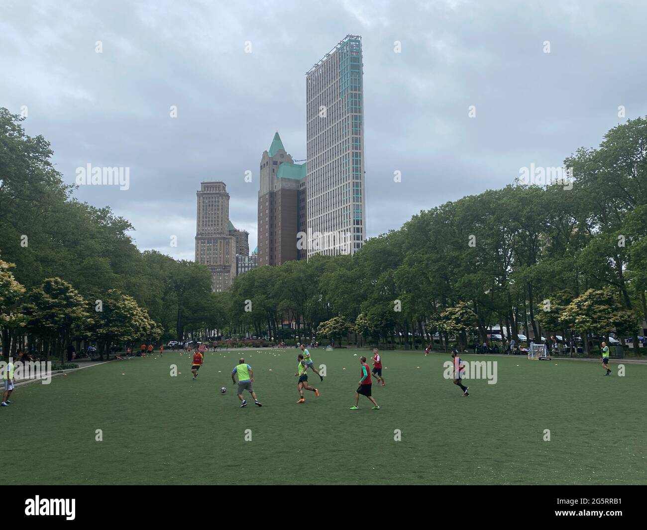 Gli uomini giocano a calcio nel parco di Cadman Plaza a Brooklyn, New York. Il calcio è cresciuto in popolarità negli Stati Uniti a causa dell'immigrazione, dove il calcio è lo sport nazionale in Europa e in America Latina. Foto Stock