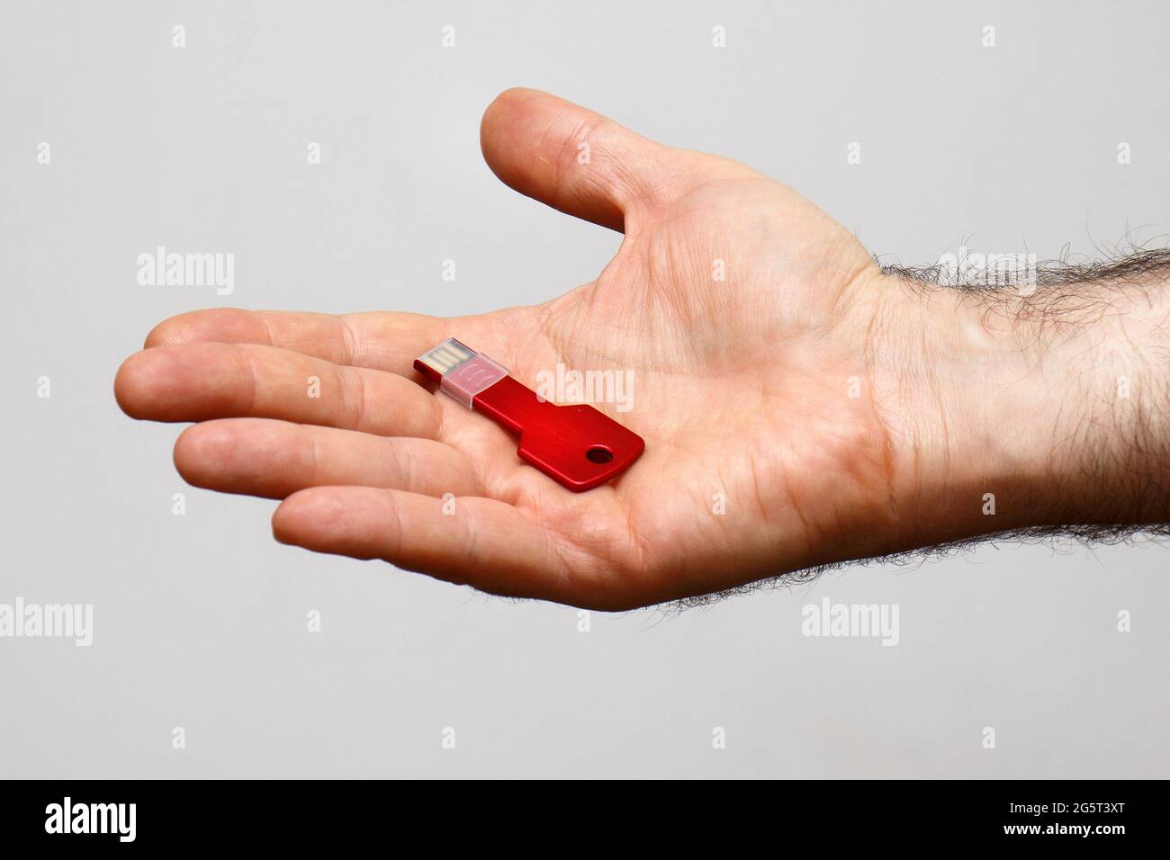 Chiave rossa sul palmo di mans che presenta file di dati segreti Foto Stock