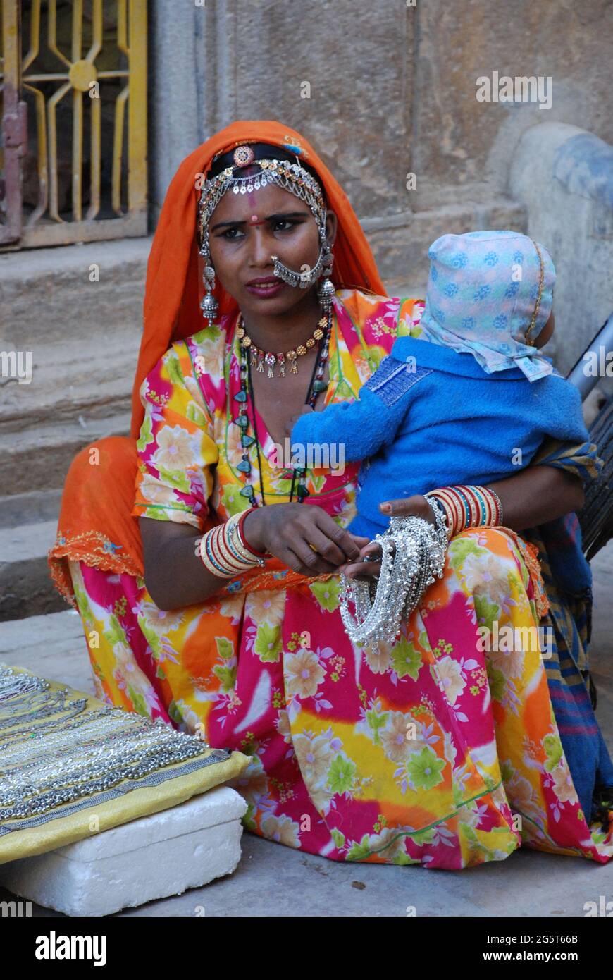 Venditore con un bambino in braccio vende gioielli , India, Radschastan, Jaisalmer Foto Stock