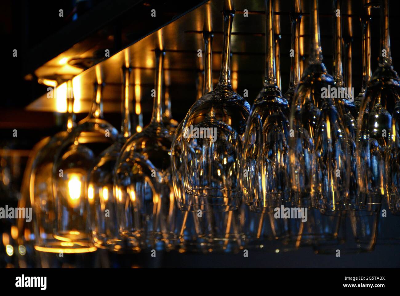 Una fila di bicchieri da vino che sbattono in un bar Foto Stock