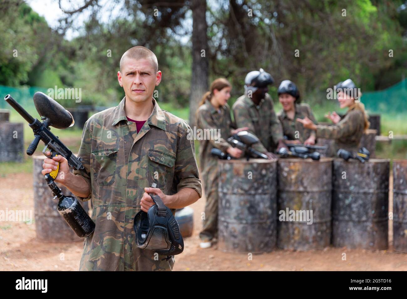 Ritratto di uomo sicuro paintball giocatore con pistola marcatore pronto per il gioco Foto Stock