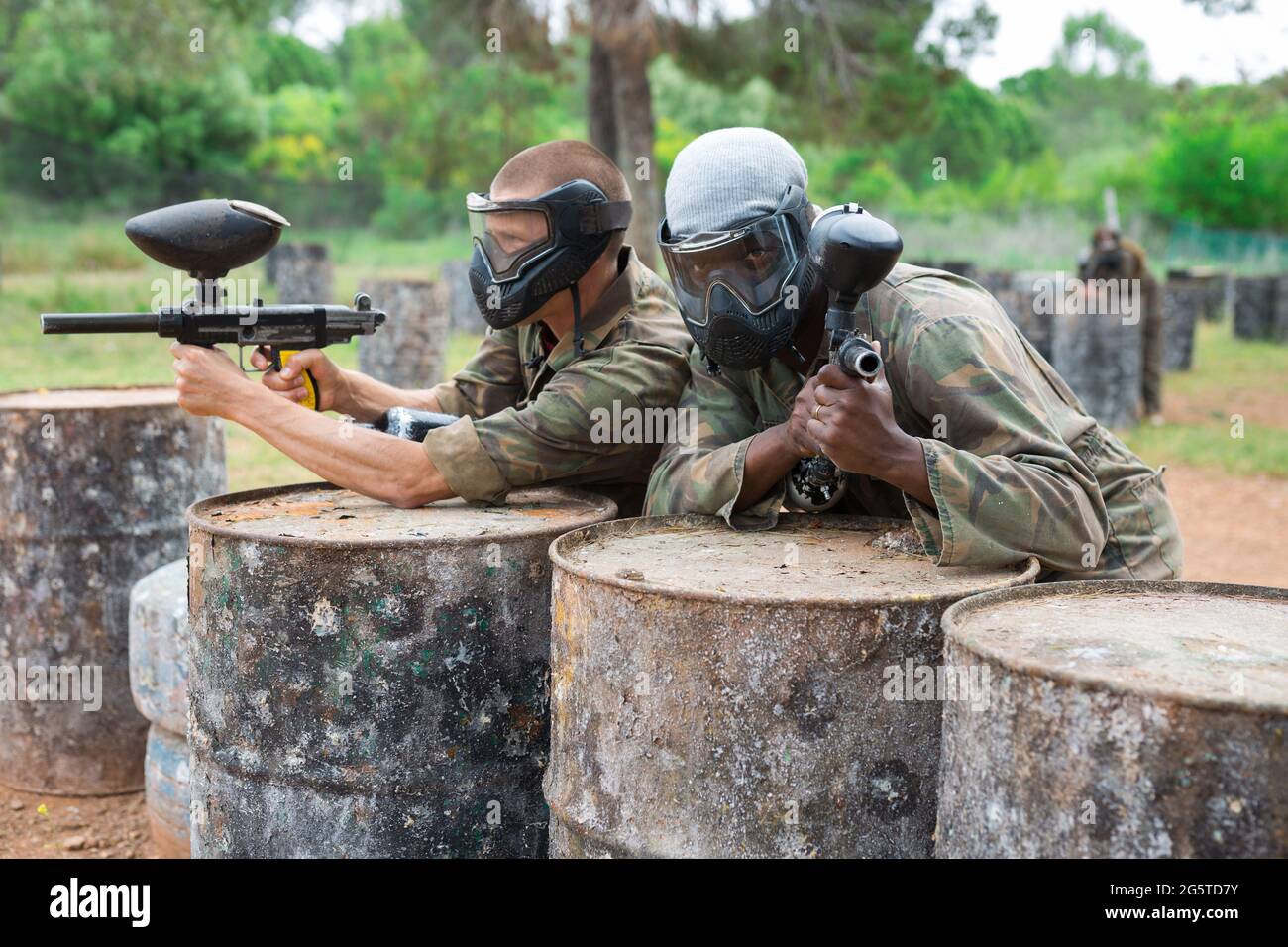 Due paintball giocatore in camouflage e maschera di mira con pistola in sparo Foto Stock