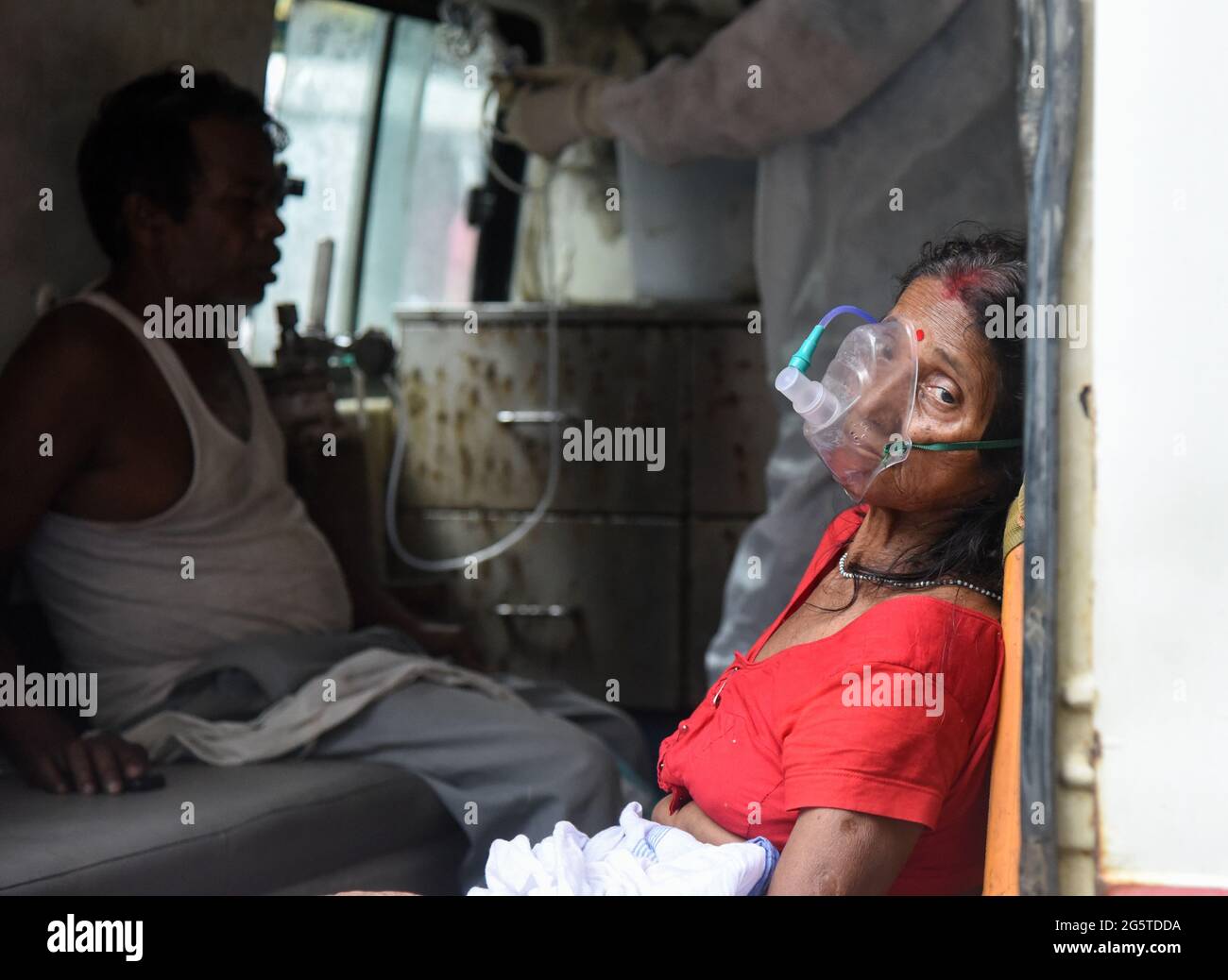 Guwahati, India. 25 Maggio 2021. Una donna con difficoltà respiratoria inala farmaci con l'aiuto di nebulizzatore maschera di ossigeno, all'interno di un'ambulanza, presso l'ospedale MMCH di Guwahati. Credit: David Talukdar/ZUMA Wire/Alamy Live News Foto Stock