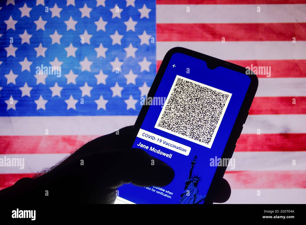 In questa illustrazione fotografica l'app Excelsior Pass fornisce una prova digitale della vaccinazione COVID-19 o risultati negativi dei test visualizzati sullo schermo di uno smartphone sullo sfondo della bandiera americana. Credit: SOPA Images Limited/Alamy Live News Foto Stock