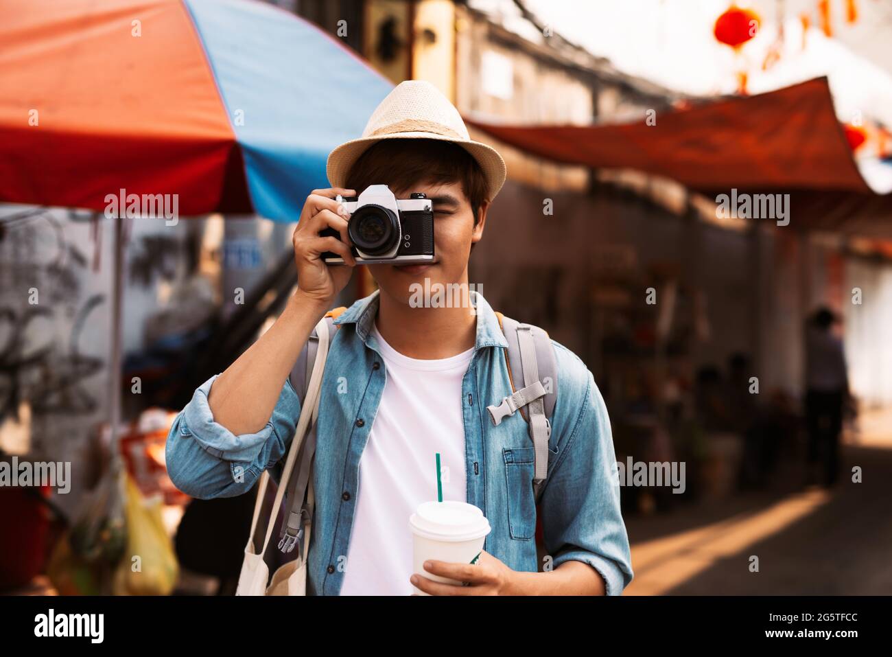 Fotografo che scatta foto di strade vivaci con ristoranti Foto Stock