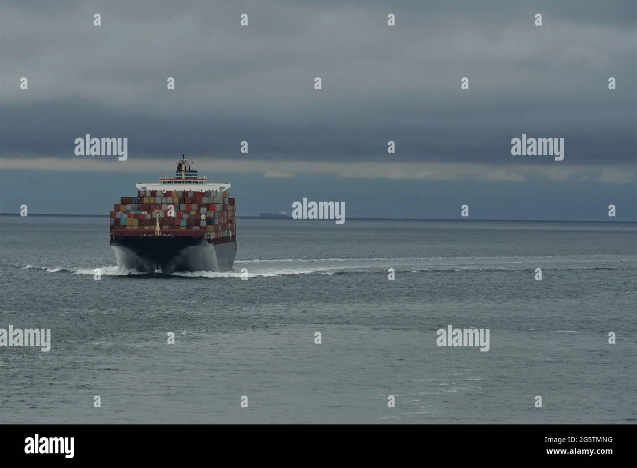 Vista su container da altra nave in corso di avvicinamento al porto di Vancouver, Canada, dall'oceano Pacifico. Foto Stock