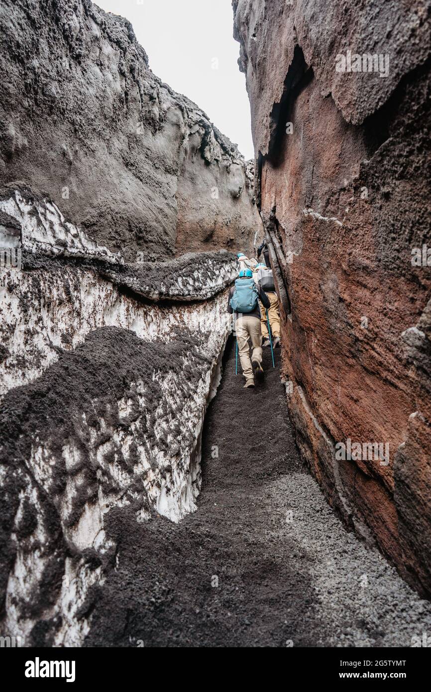 Backpacker in casco escursioni a Etna protetta zona naturale, Sicilia, Italy.Adventure attività all'aperto.escursione alla cima del vulcano, trekking tunnel. Foto Stock