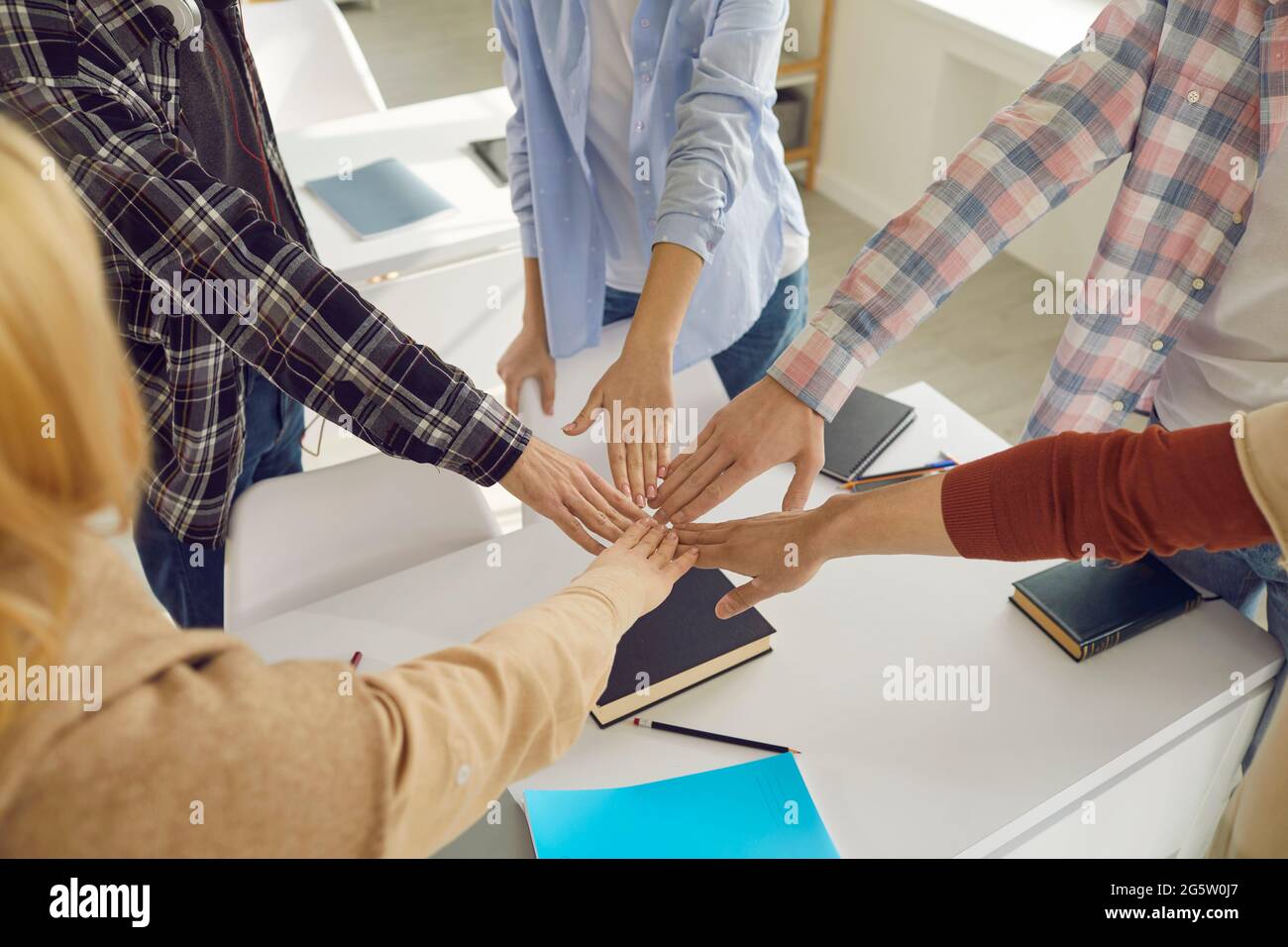 Il gruppo di studenti delle scuole superiori o dell'università si unisce alle mani promettendo di sostenersi l'un l'altro Foto Stock