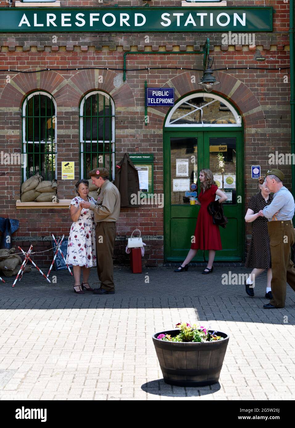 Vista generale dell'esterno della stazione ferroviaria di Alresford con le persone negli anni '40 vestirsi durante l'evento annuale War on the Line, Alresford, Hampshire, Regno Unito. Foto Stock