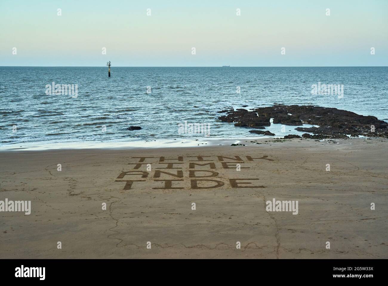 Pensare tempo e marea messaggio di avvertimento su una spiaggia Foto Stock