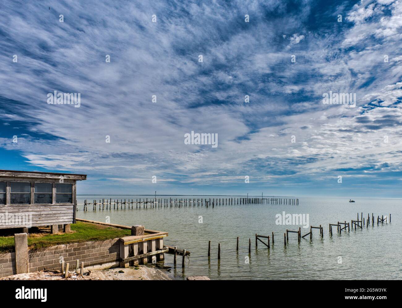 Ruined molo a Baffin Bay, Gulf Coast, barca in distanza, vista dalla frazione di Riviera Beach, vicino a Kingsville, Texas, Stati Uniti Foto Stock