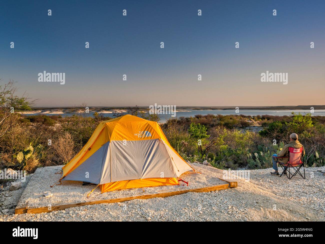 Camper che guarda il lago artificiale Amistad all'alba, campeggio Governors Landing, vicino a del Rio, Texas, USA Foto Stock